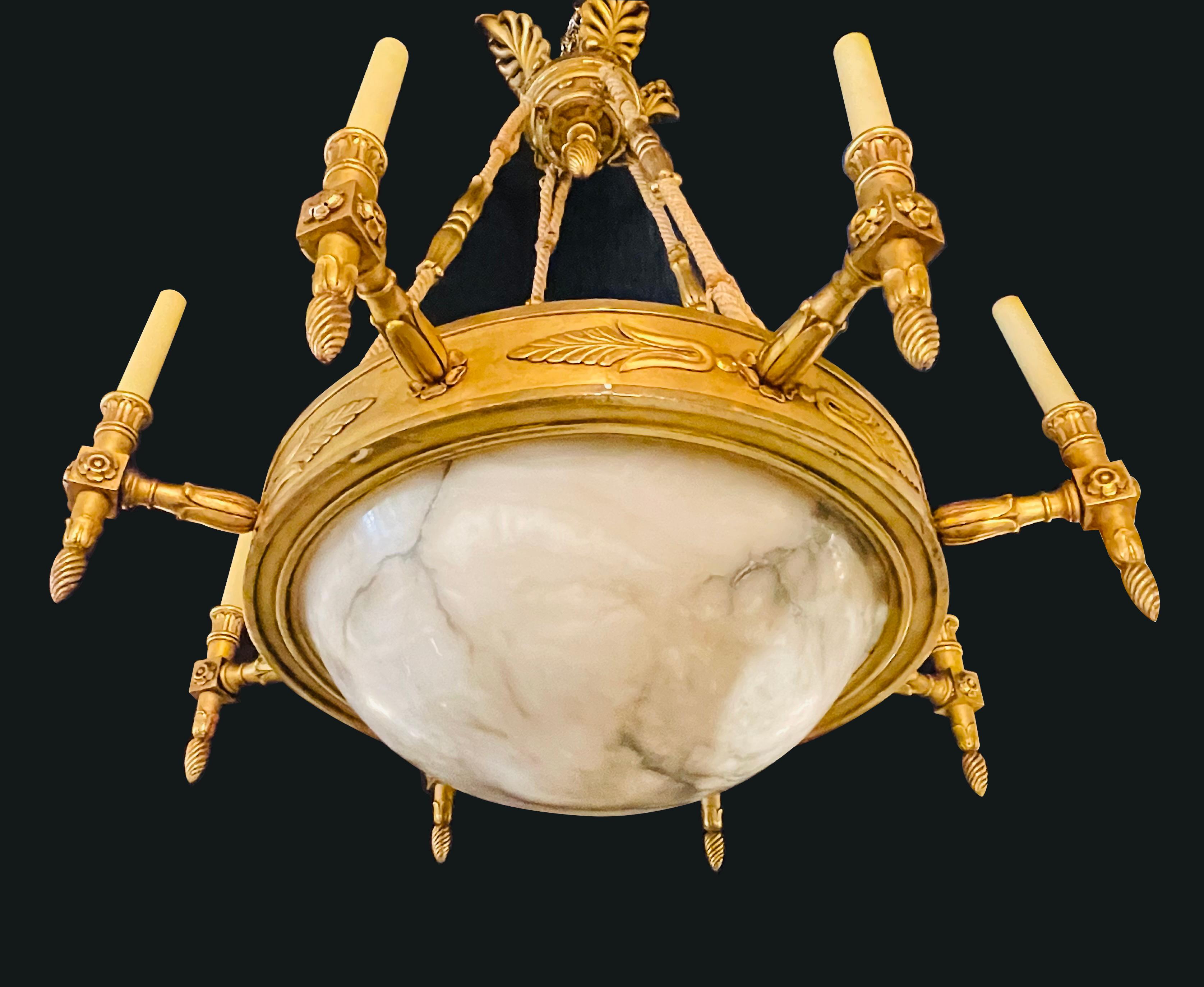 19th-20th century alabaster and giltwood chandelier. A stunning neoclassical chandelier having a large domed alabaster globe supported by a finely carved giltwood apron with eight giltwood carved candelabras lights. The whole suspended by rope and
