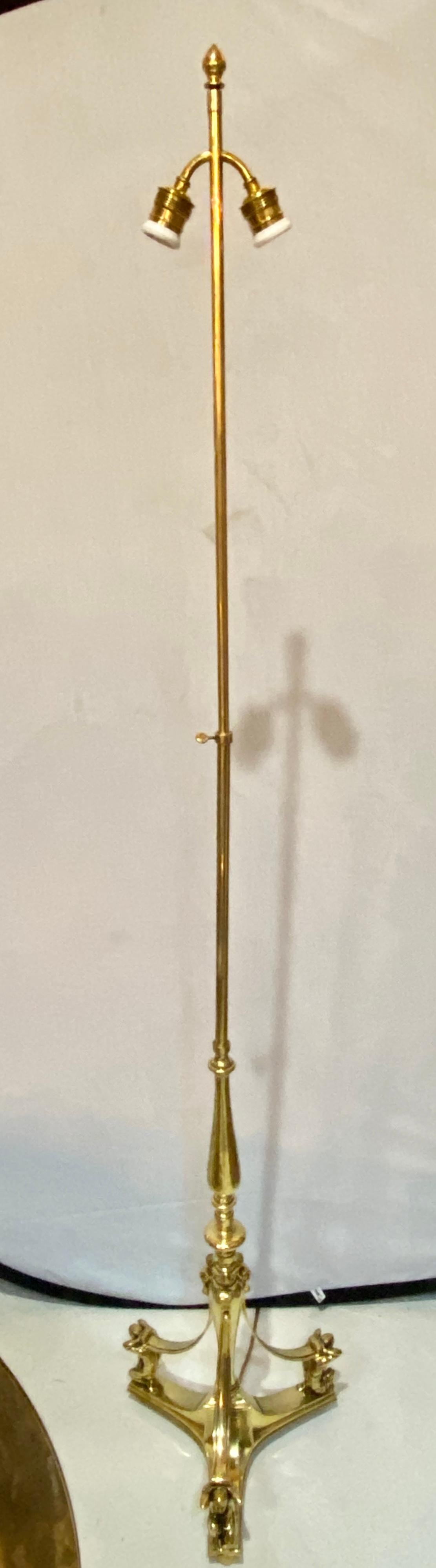 19th-20th century Atlas figural standing tall lamp. This Fine Empire Style bronze standing floor lamp takes one bulb and has a custom lamp shade. The long sleek bronze center column-form supported by a tripod base having three figures of an Atlas
