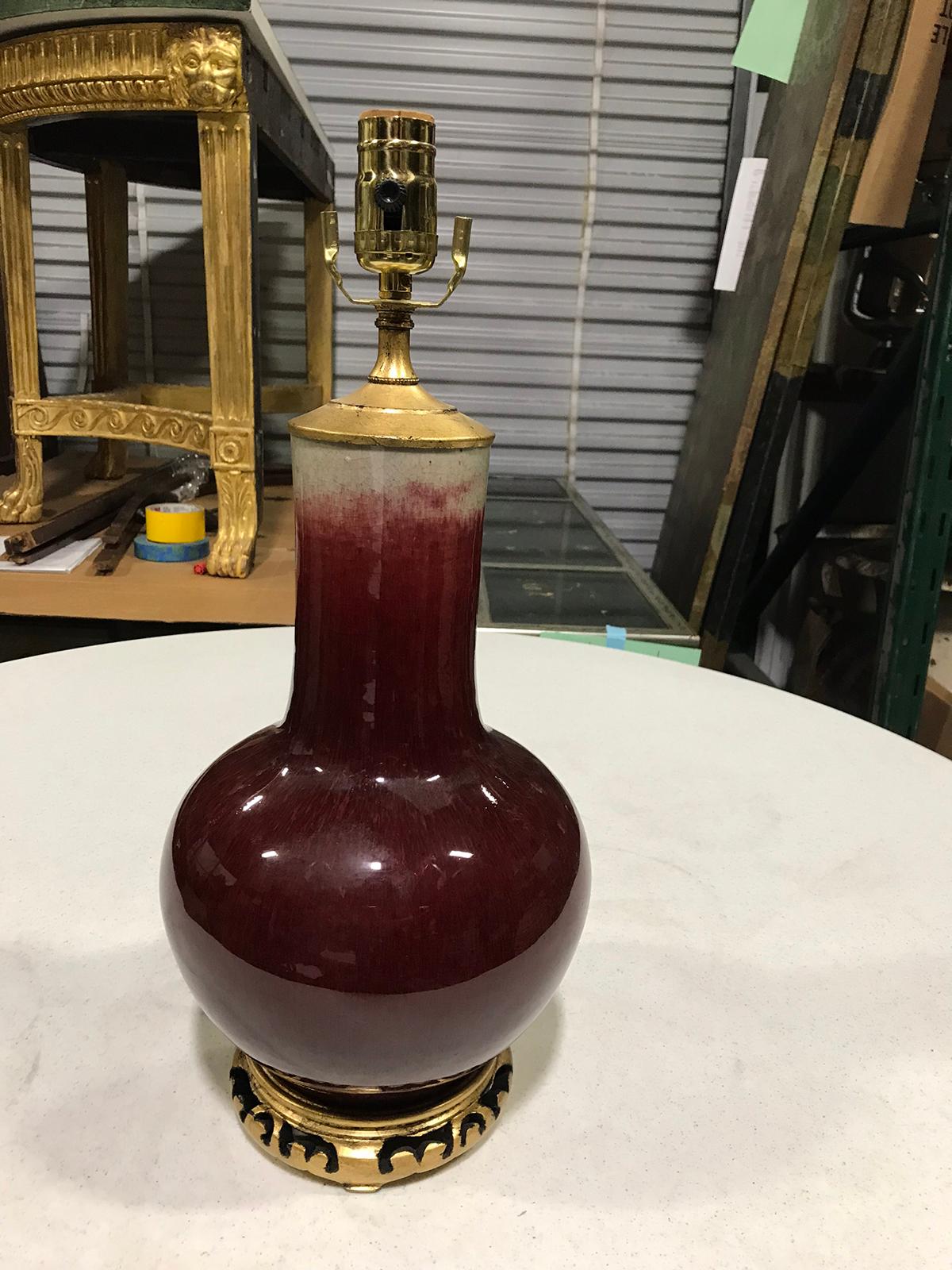19th-20th century Chinese Sang de Boeuf oxblood porcelain vase as lamp
Giltwood base
New wiring.