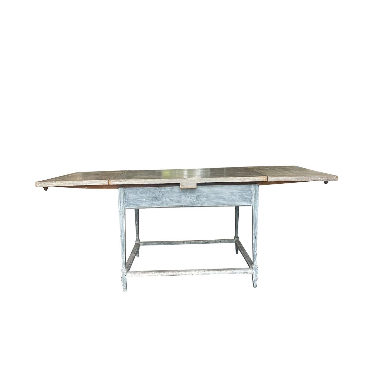 Ancienne table de cuisine pliante provençale française du 19e siècle - 20e siècle, en bois de pin travaillé à la main, en bon état. La base de la table de salle à manger présente une patine bleue pâle appliquée et détaillée. Le plateau antique a une