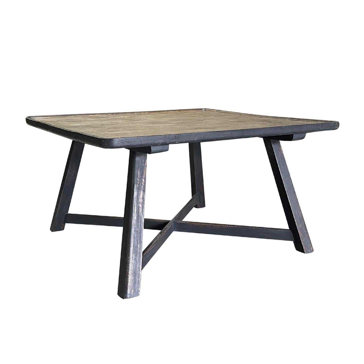 Une effrayante table de canapé provençale française ancienne en bois de pin peint à la main, en bon état. La table d'appoint rustique est caractérisée par une patine de couleur sombre. Elle repose sur quatre longs pieds en bois inclinés, soutenus