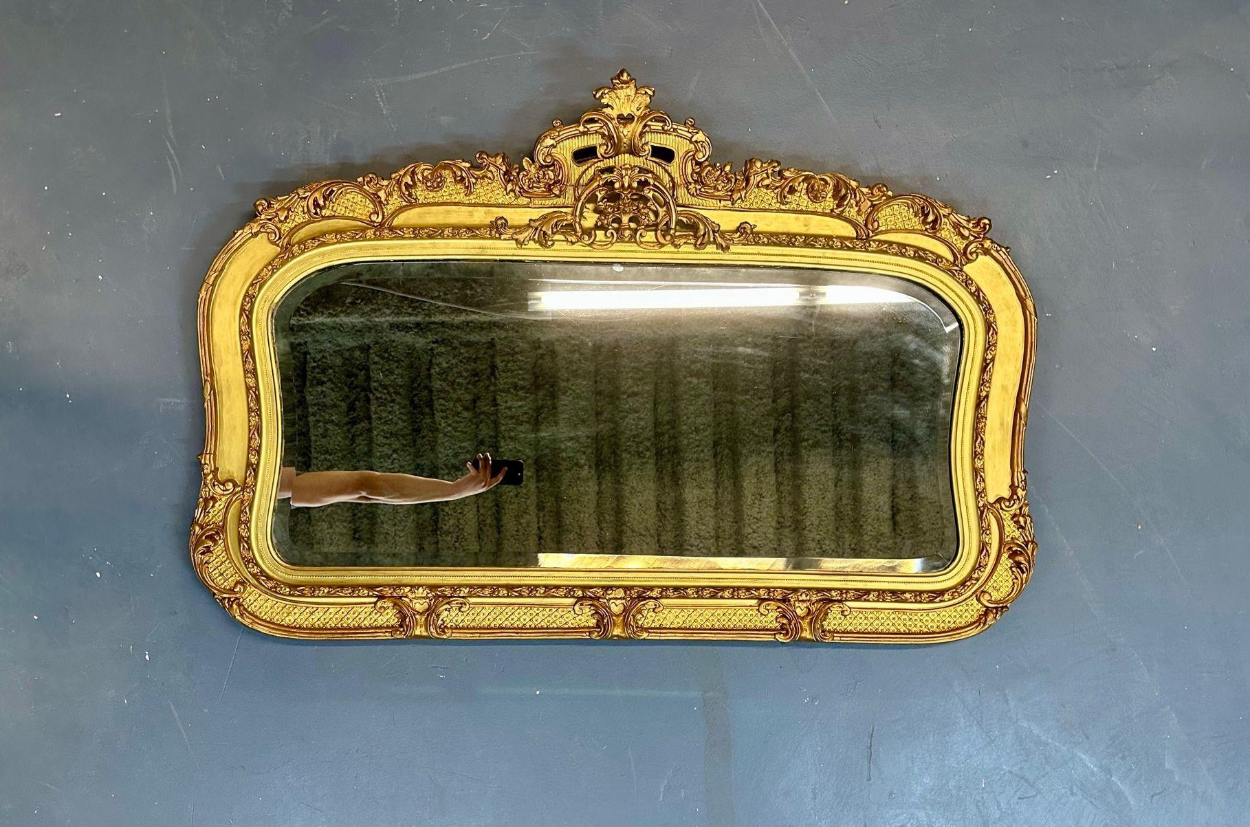 19th/ 20th Century Giltwood Wall / Console / Pier Mirror, Over the Mantle, Rectangular
 
A finely carved and decorative gilt wood and gesso wall mirror having a 24 kt gold finish. The center rectangular beveled mirror having a fine rose, leaf,