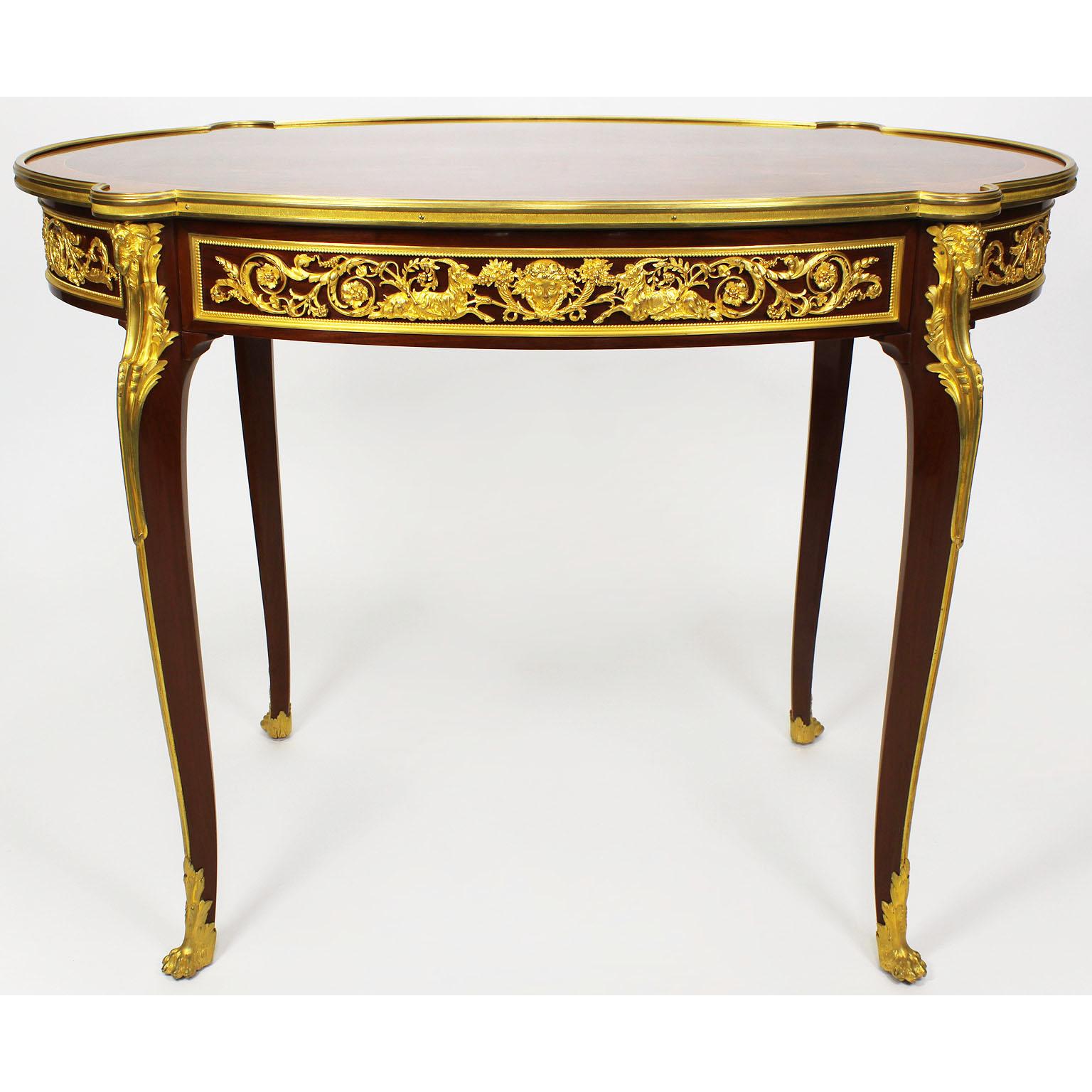 Très belle table centrale ovale de style Louis XV du 19e/20e siècle en acajou, noyer et placage de satiné, montée sur bronze doré et dotée d'un tiroir en frise, attribuée à Franc¸ois Linke (1855-1946). Le plateau est orné d'un motif de parquet en