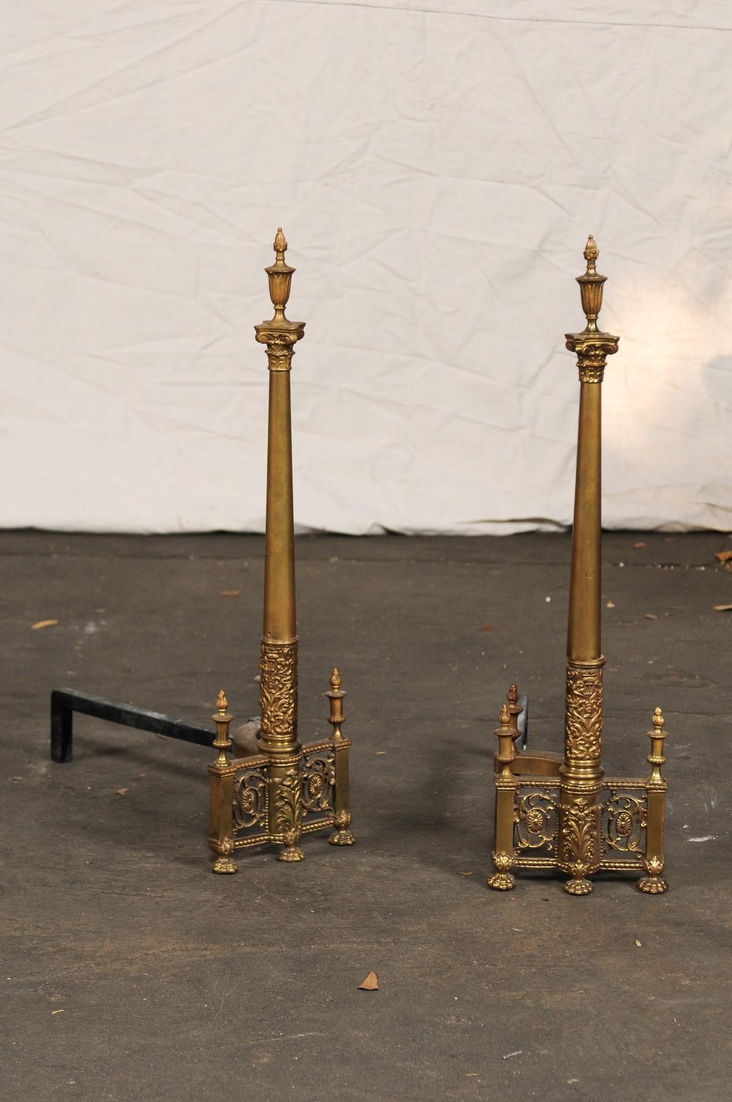 19th-20th century neoclassical brass andirons, columns with flaming urns, paw feet
Great detail.