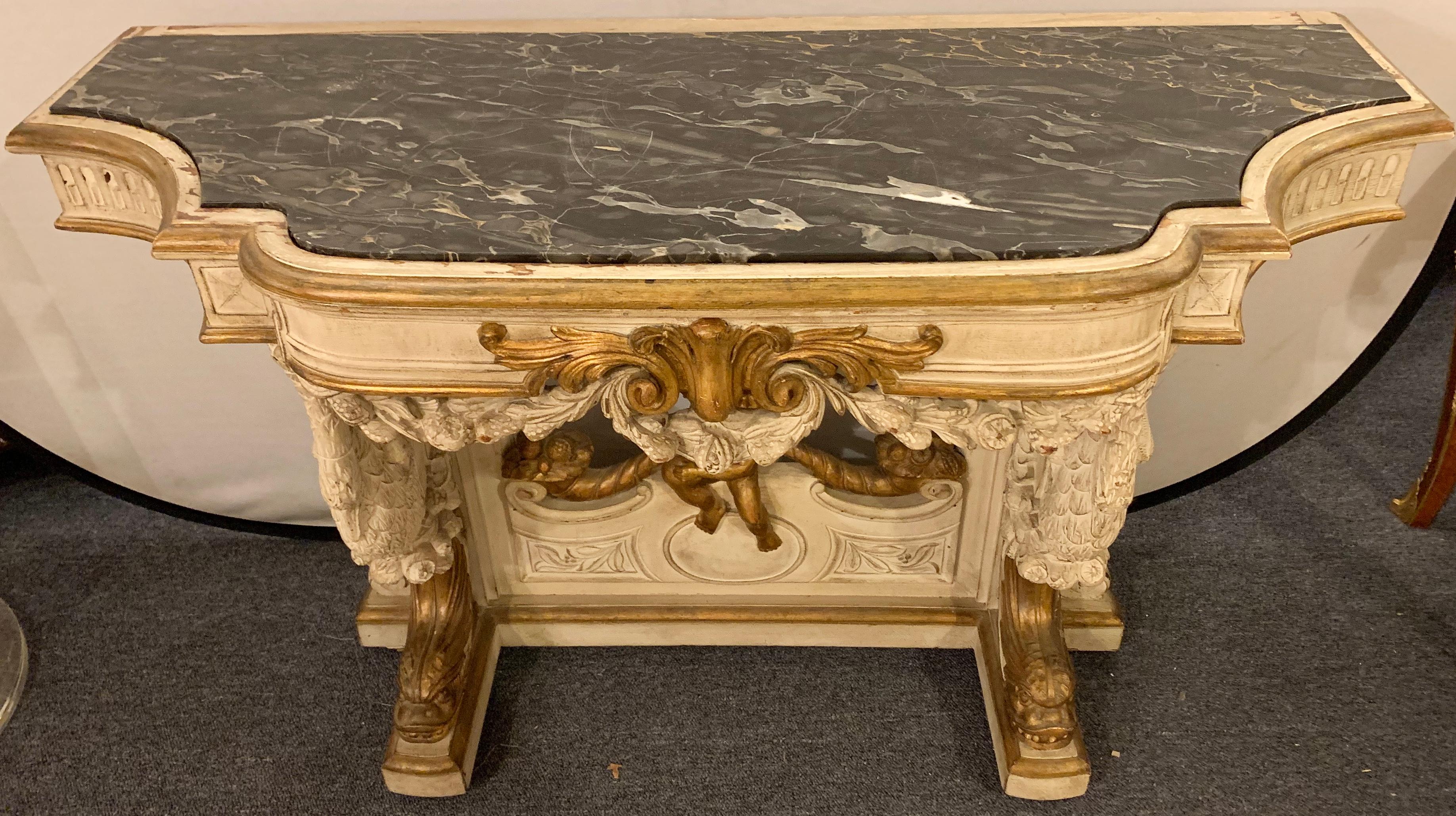 19th-20th century painted and parcel gilt console sideboard or server. A spectacular carved and painted console table having a black and gray white veined marble top above a base of gilt dolphins and cherub.

Greg
4500/EXAX.