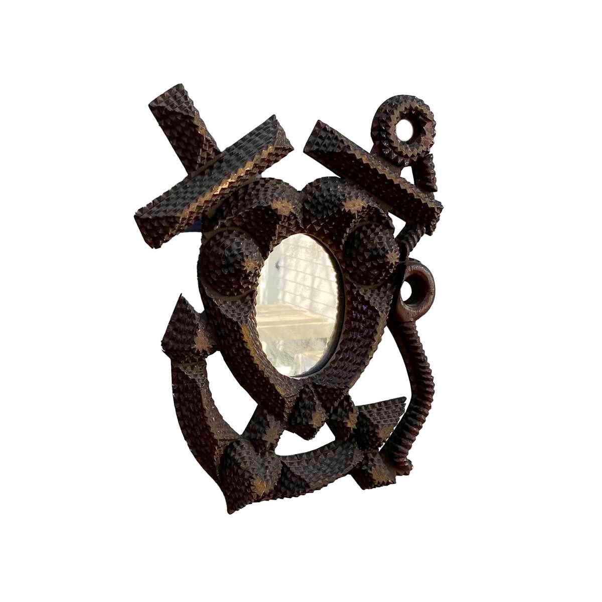 Late 19th-early 20th century tramp art frame having a central heart with oval mirror and with a crossed anchor and cross. The frame is made up of chip carved stacked layers as well as a carved anchor line.