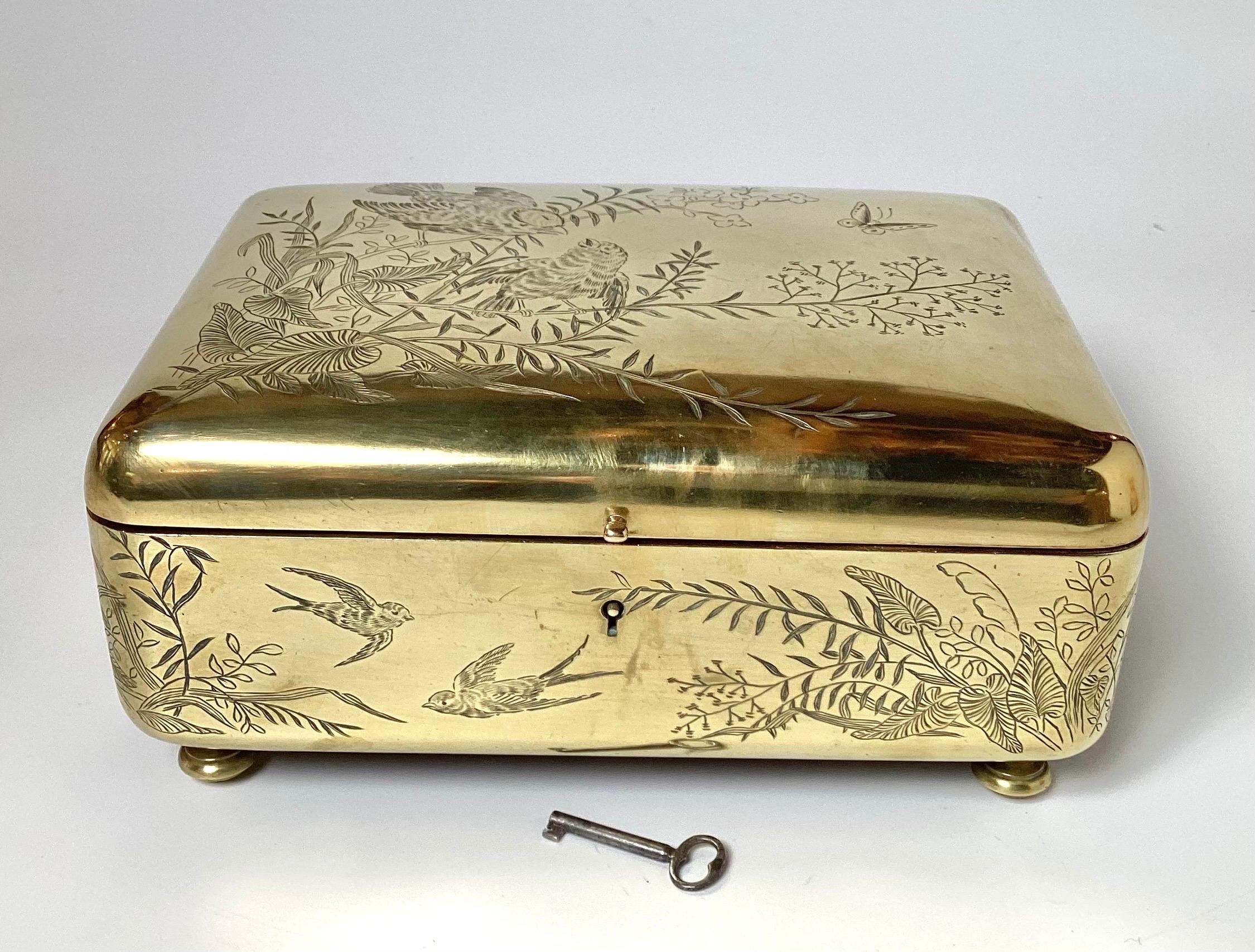 A polished brass Aesthetic movement engraved decoration jewelry box, table box. The bright finish with love birds, leaves, branches and vines with a working key. The velvet lining is in good condition but original with some fading.