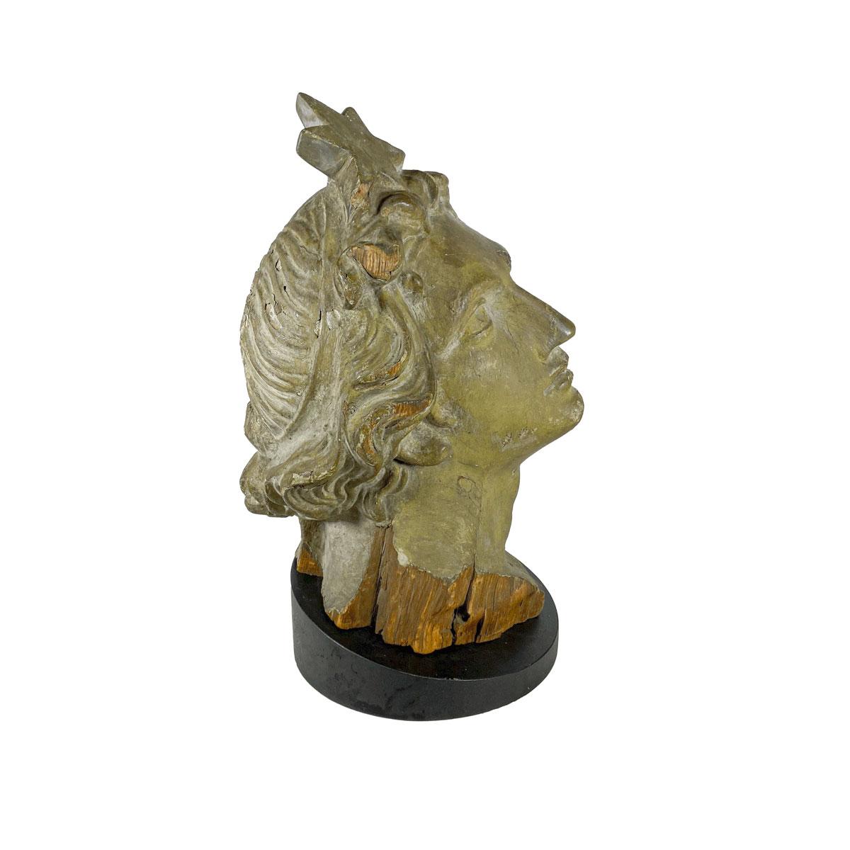 A masterfully carved pine head of Lady Liberty in an upward gazing pose and wearing a headband with a large star, on a custom base. Painted in verdigris green, the carving was probably part of a larger carving, perhaps a ships figurehead or for a