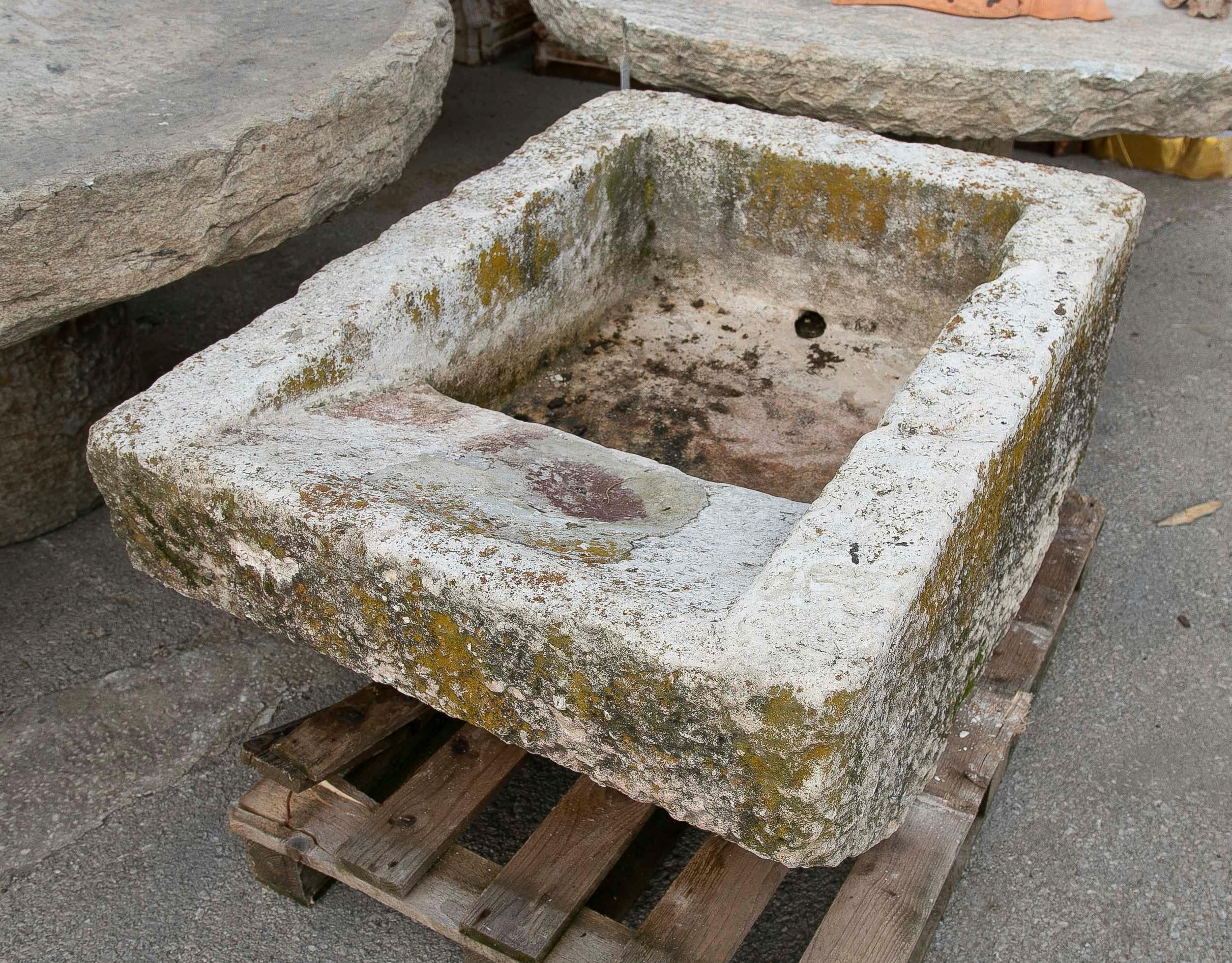 Antique washbasin carved from a single block of stone, with an attractive rustic finish and an authentic patina formed over the years. It features irregular textures, traces of moss, and signs of use that lend it great decorative character. Ideal