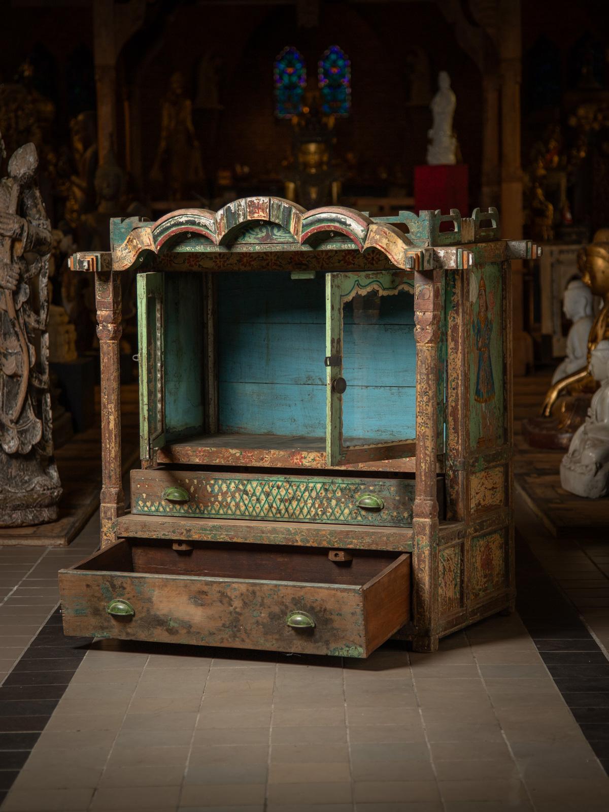 Questo antico tempio indiano in legno è un capolavoro del XIX secolo, realizzato in legno di alta qualità e adornato con intricate decorazioni e figure dipinte su ogni lato. Con un'altezza di 110,5 cm, una larghezza di 110,5 cm e una profondità di