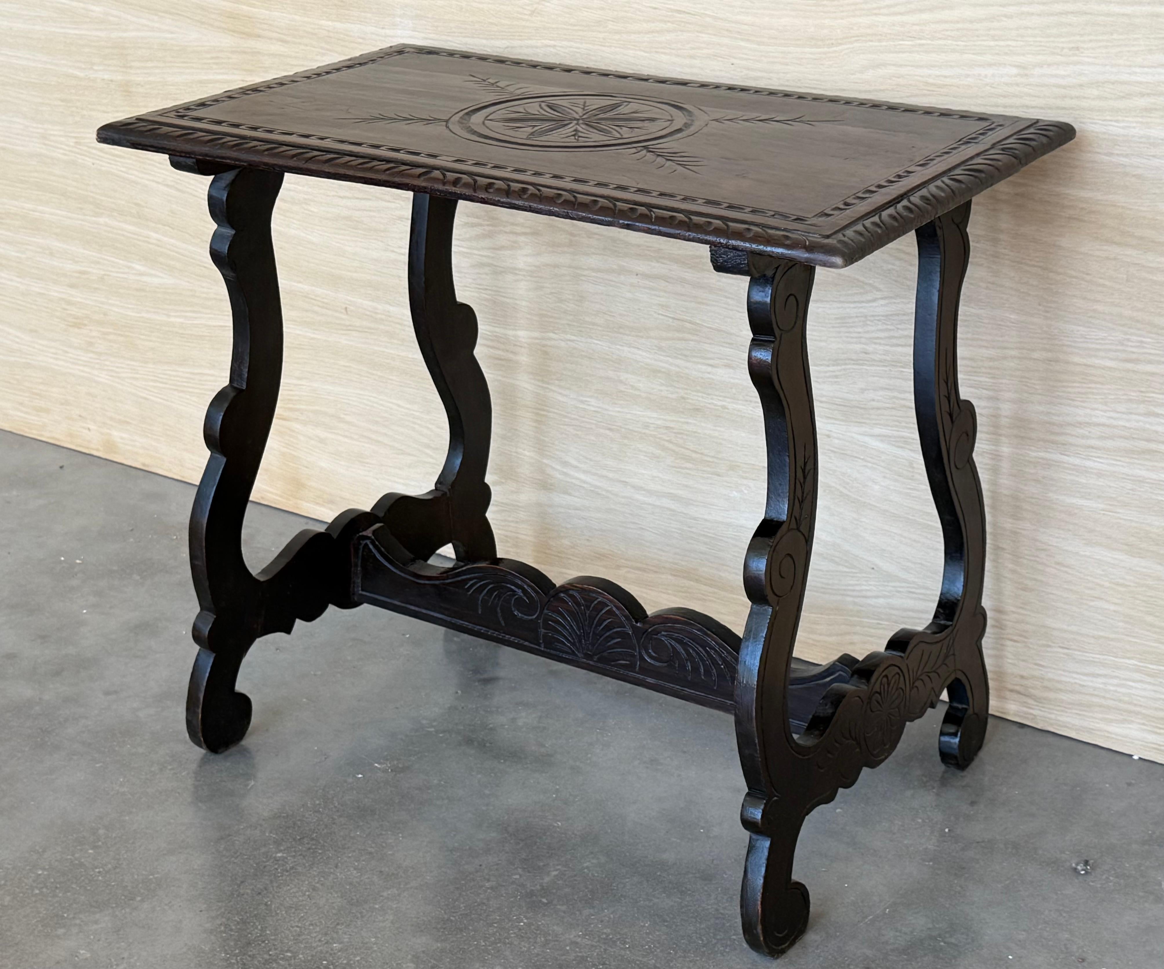 19th century Spanish trestle table in walnut. This piece has a great scale, lovely carved lyre legs and beautiful ebonized top. 
The table has carved edges front in all sides.
This table could be used as an end table, nightstand, side table or small