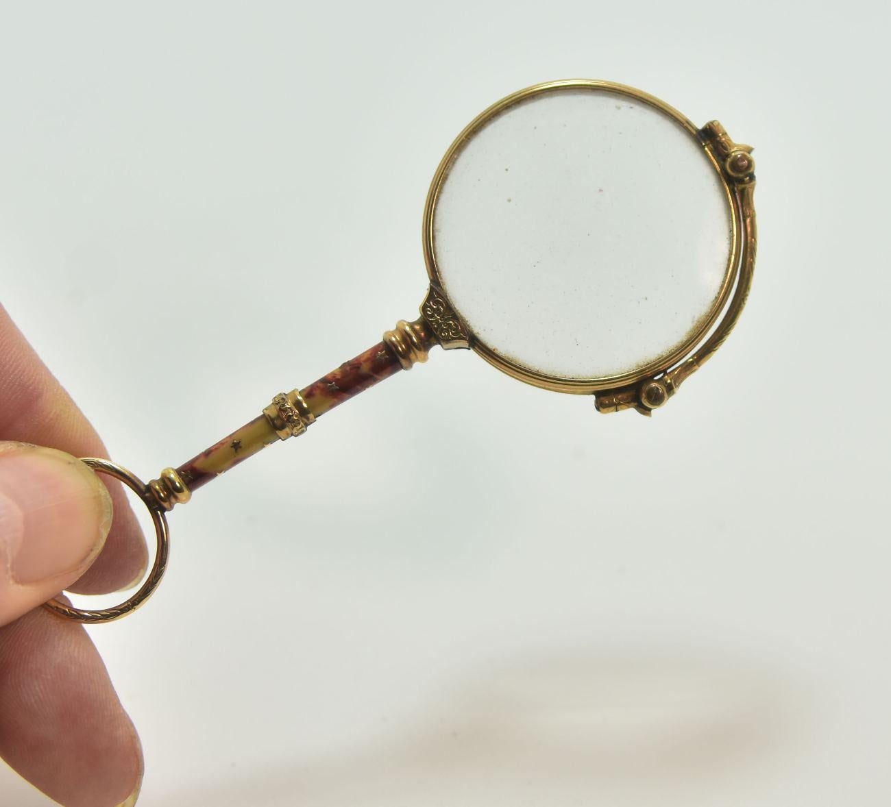 Binocular or face to hand in gold and enamel from the 19th century hallmark of a goldsmith T S with a kind of cedar in the middle dimension 10.5 cm for a weight of 21.9 grs.