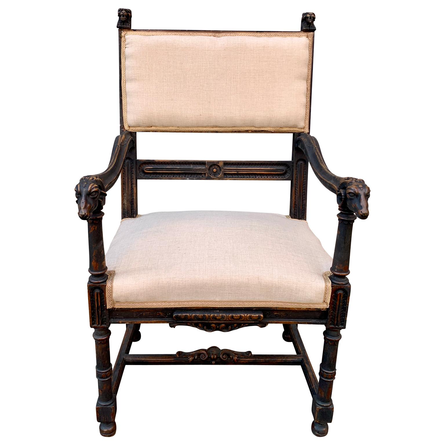 Late 19th Century French writing desk armchair painted in black, in solid oak wood. This richly sculptured armchair from Gothic revival period, is decorated with rams head on the armrest and lions head on the top of the back.