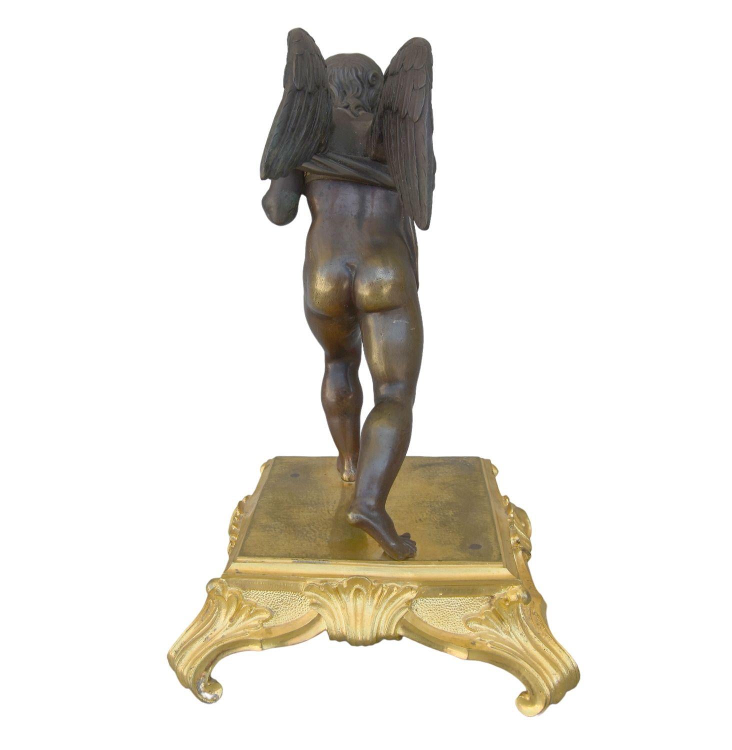 Amour aveugle en bronze du 19ème siècle symbolisé par un cupidon semblant jouer au maillot de bain à patine brune sur socle en bronze doré. Notez une différence de patine entre la partie supérieure et la partie inférieure de l'ange. Hauteur de 25 cm