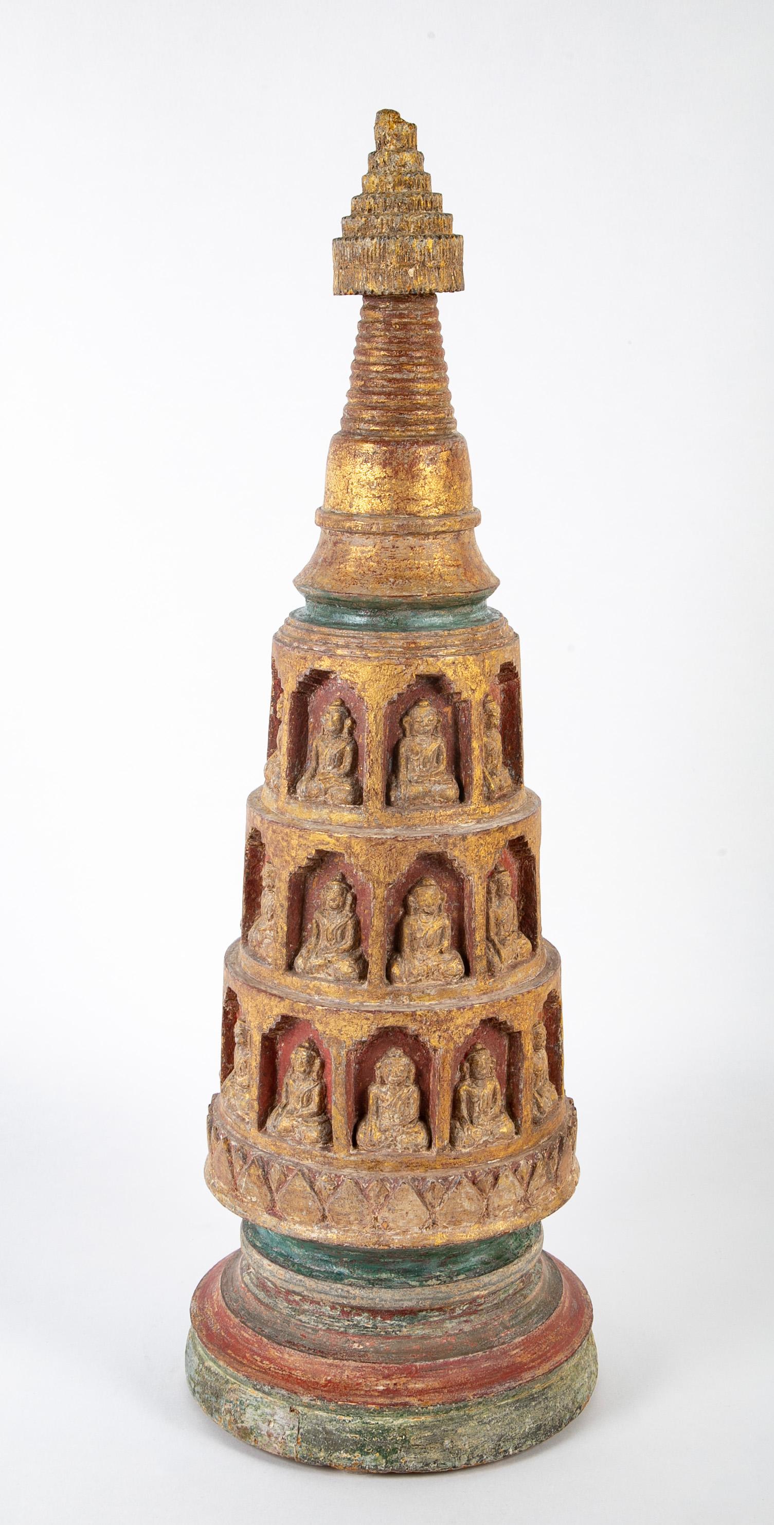 A wonderfully carved 18th century Burmese Shan period stupa with many seated Buddha's set in niches. With original gilding and red and green polychrome. 
The stupa is a Buddhist architectural monument honoring a sacred site. Lovely worn surface