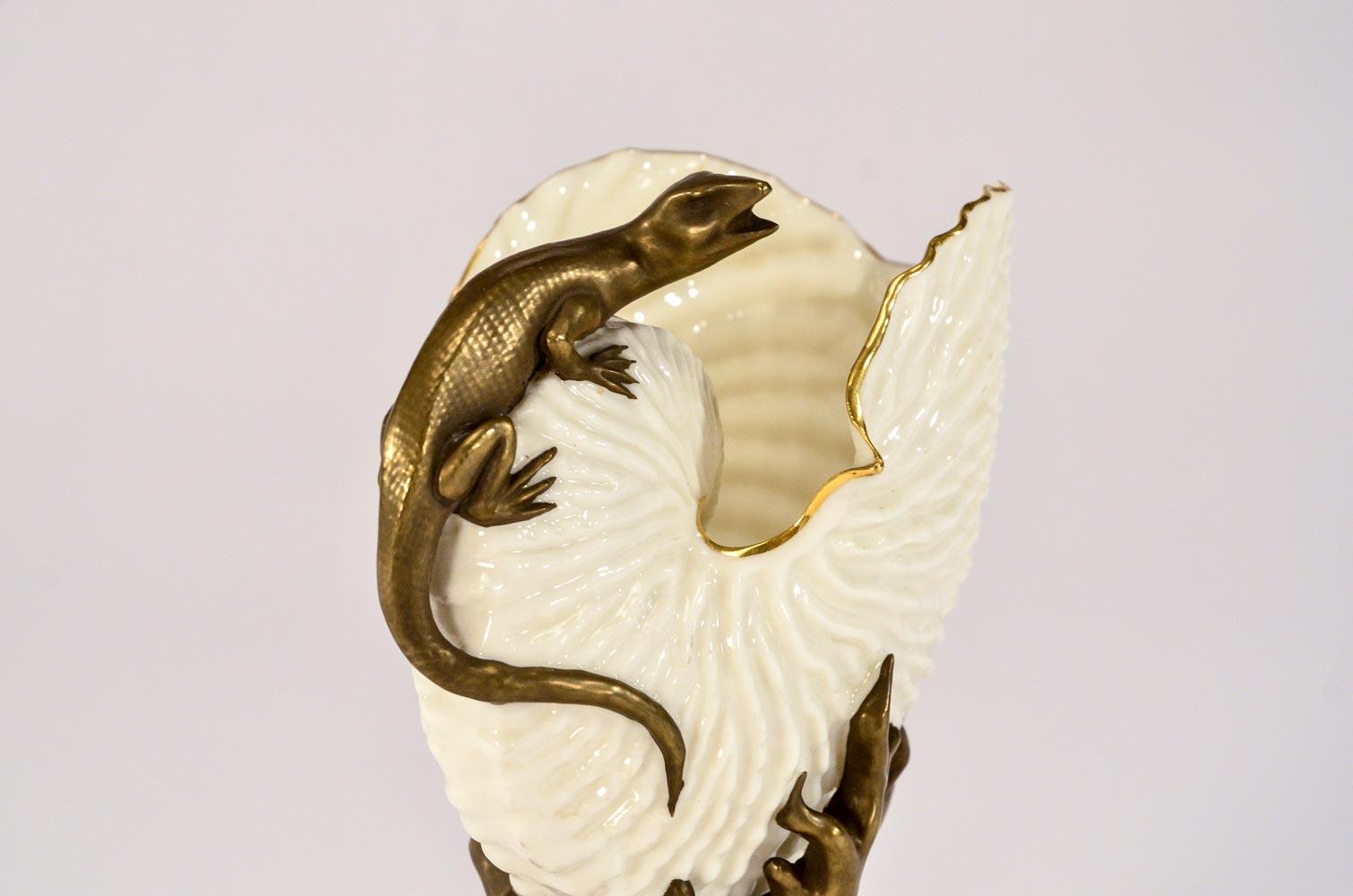 This rare example of Aesthetic movement ivory porcelain themed vases features the curious perched salamander inspecting the contents of the open shell. The translucent wall allows light that highlights the realistic shape and relief of the form. The