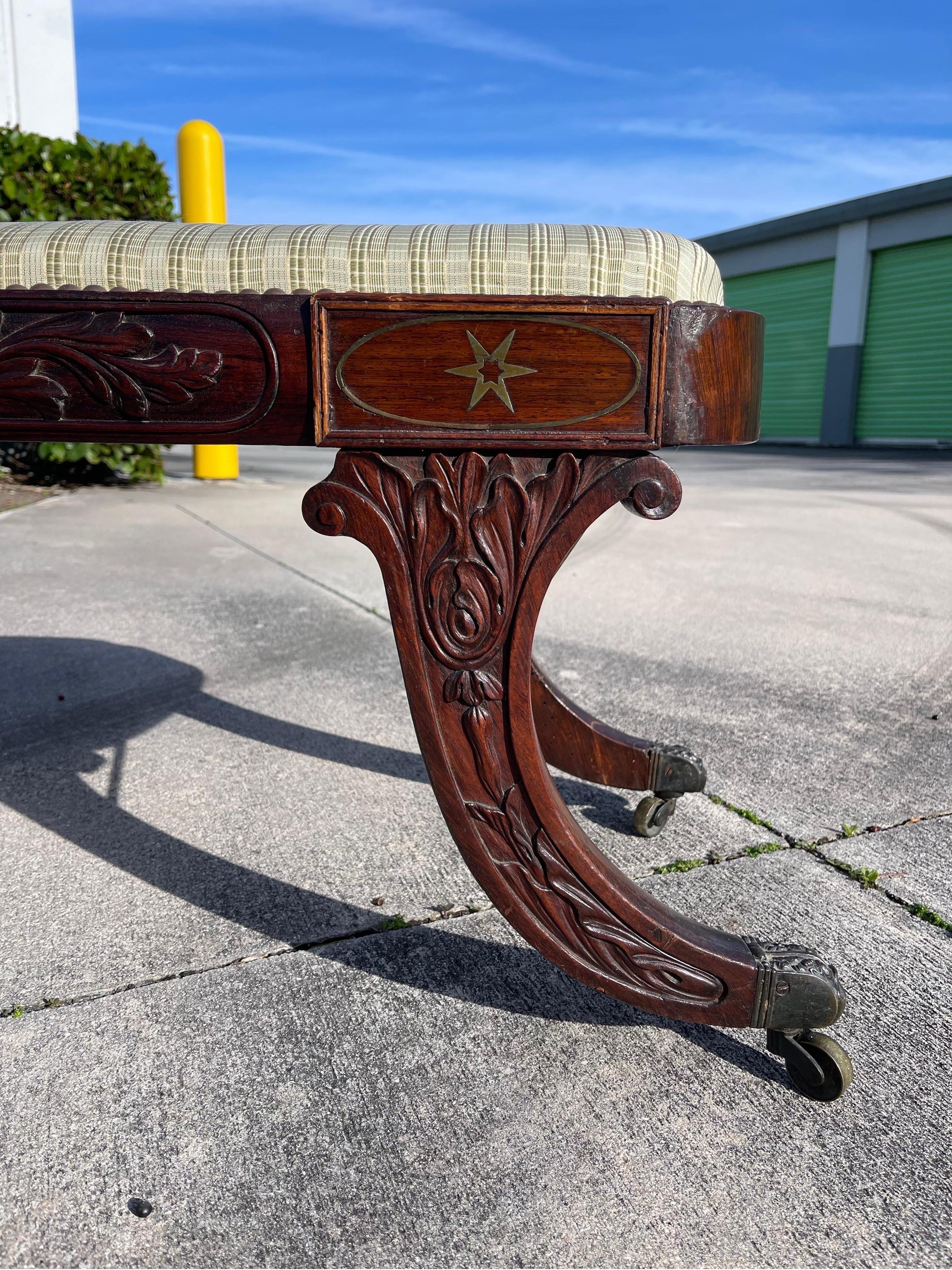 Handsome carved mahogany bench, dating to the early 1800s, in the manner of Duncan Phyfe. One side ornately carved, one side plain — likely intended to sit against a wall, under a window, between pillars, and so on.
