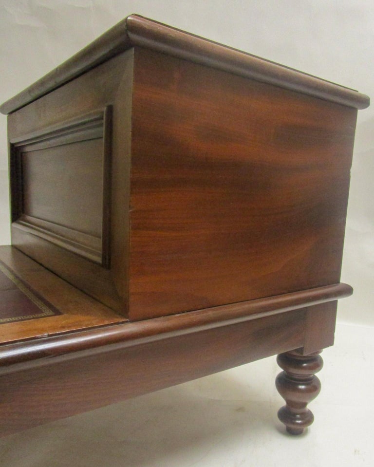 Handsome and sturdy American walnut library or bed stairs feature two hinged steps. Bottom step lifts to reveal ample storage inside. Features include burgandy leather with tooled Greek Key pattern border on the two steps and short, turned Sheraton