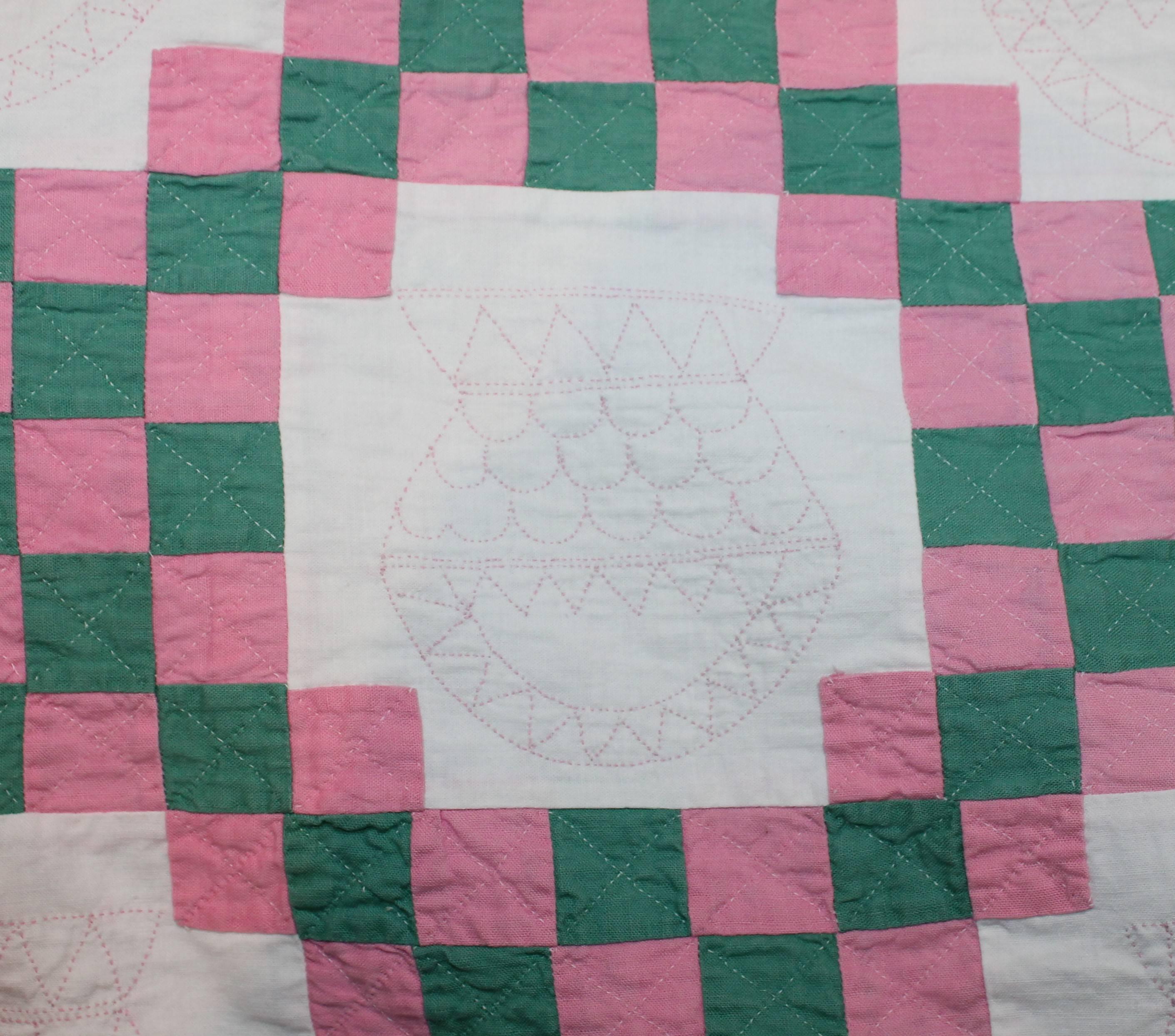 19th century Amish postage stamp chain in pink and green. This fine Lancaster County, Pennsylvania quilt has amazing basket quilting and very finely pieced. This is a summer quilt. Which means it is finely made and thin with very little batting.