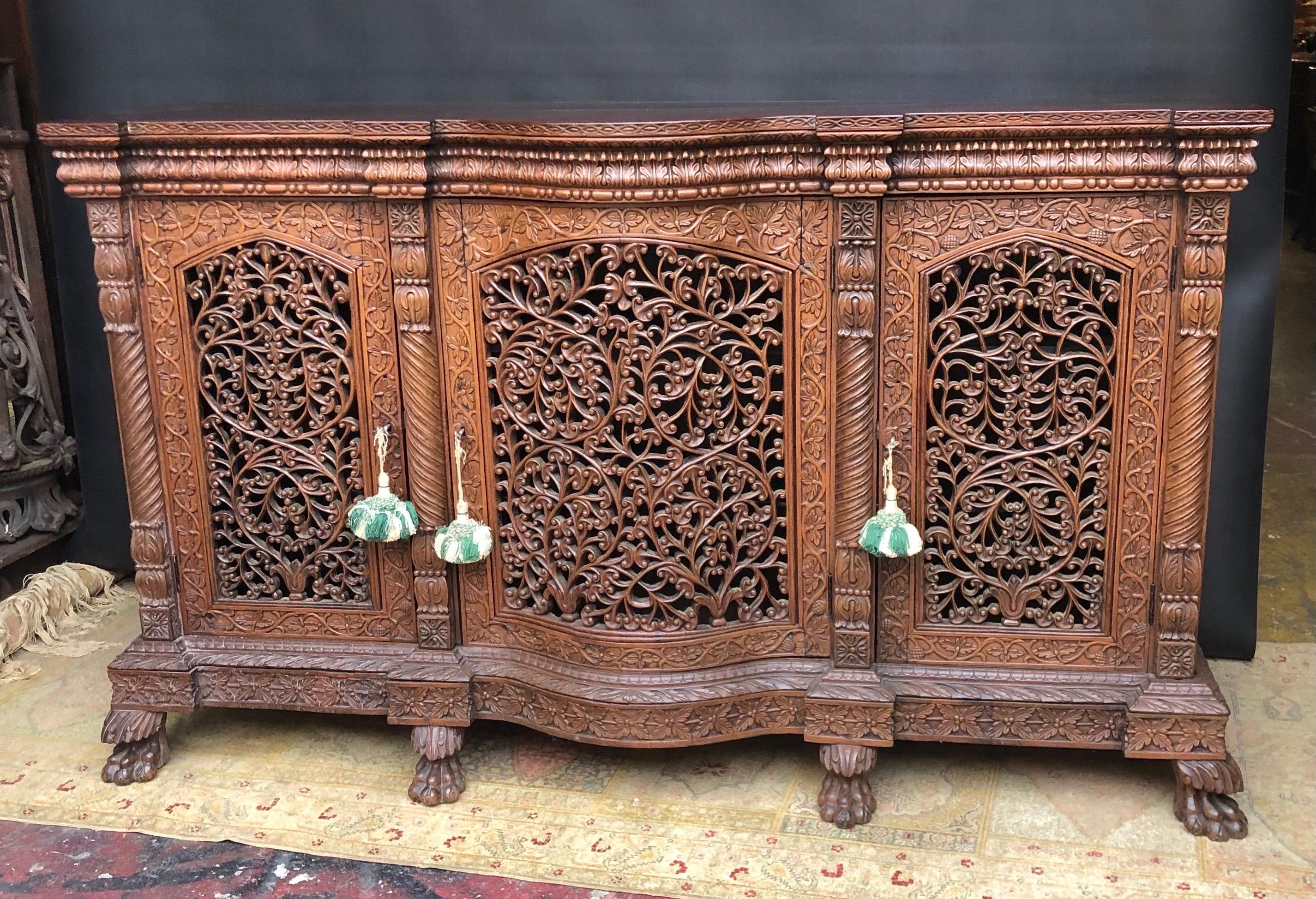 This Regal Anglo Indian Regency Carved Mahogany & Padouk Sideboard / Credenza was handmade in the Nineteenth Century.  The British Colonial Sideboard is hand carved solid mahogany and padouk wood. The highly carved cabinet has a highly figured solid