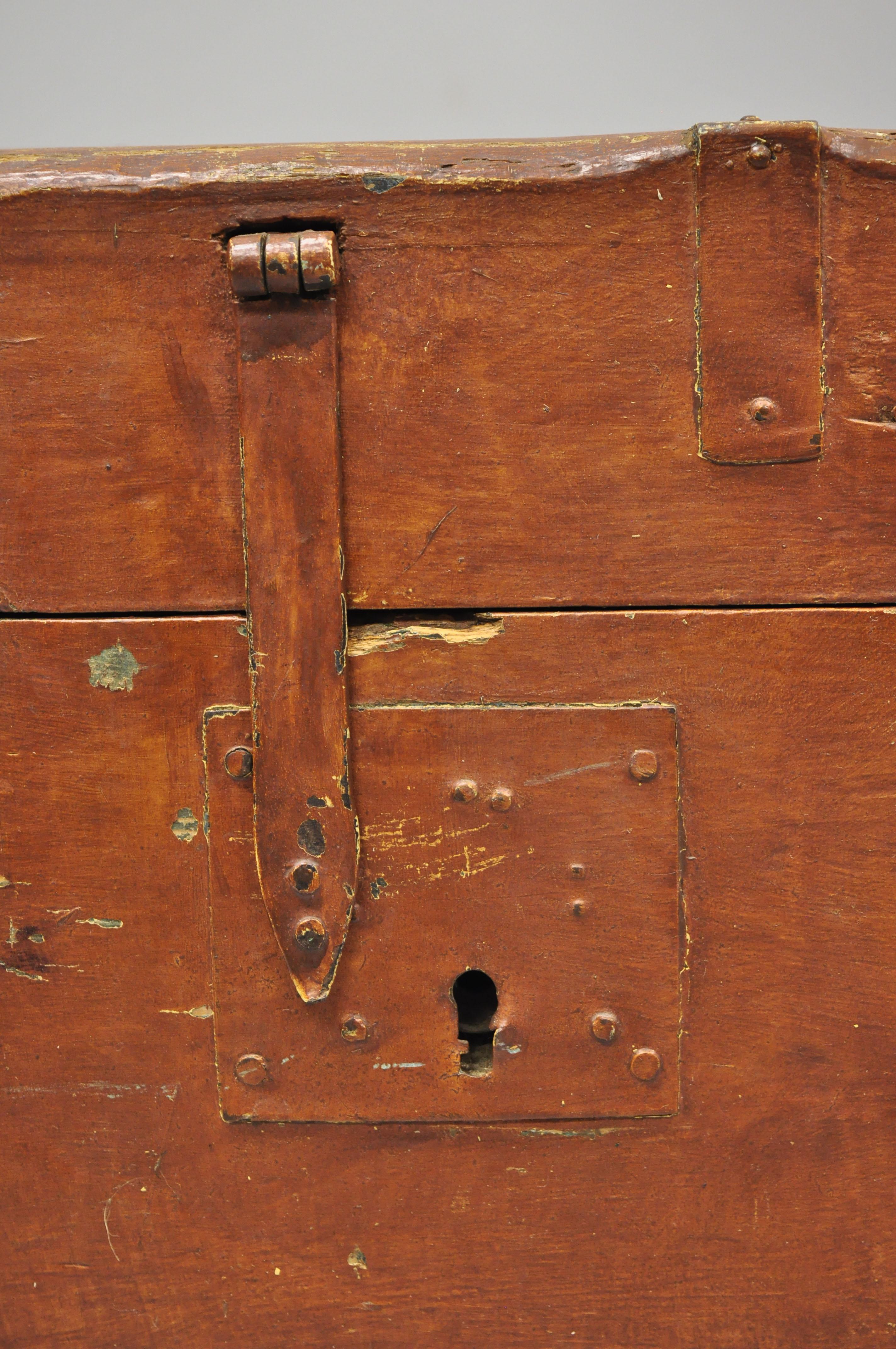 19th century antique brown distressed painted pine wood dovetailed blanket chest trunk. Item features dovetailed construction, weathered/reddish brown distressed painted finish, rolling casters, cast iron hardware, locks do not work, solid wood