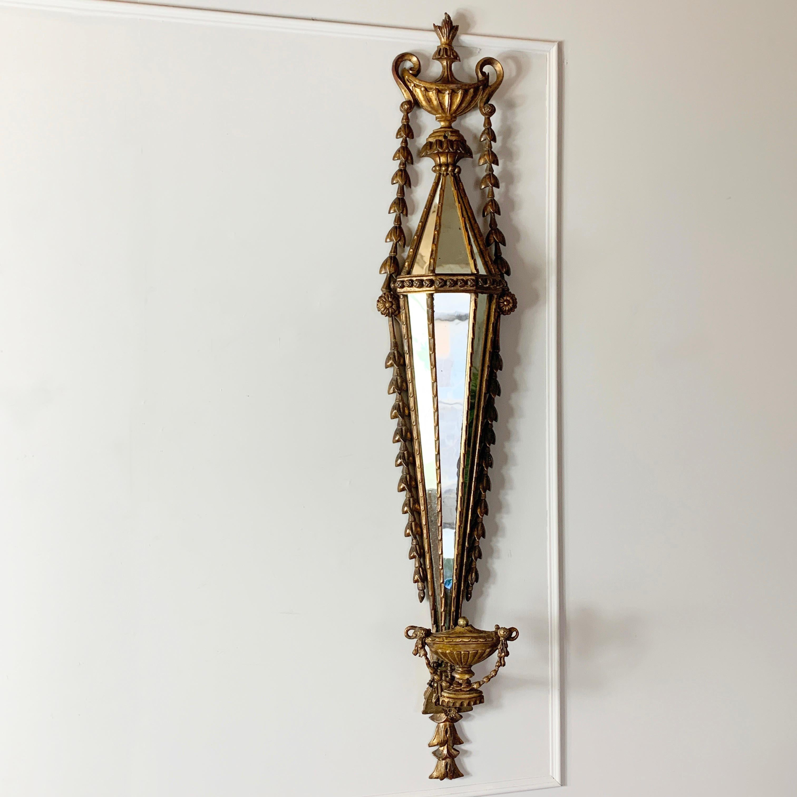 Antiker französischer Wandleuchter mit vergoldetem Facettenspiegel. Geschnitztes und vergoldetes Holz im Louis-XVI-Stil, verziert mit Blattgirlanden und Urnen, 19.
Im Inneren der Leuchte befinden sich 6 Einzelspiegel, die das Licht in verschiedenen