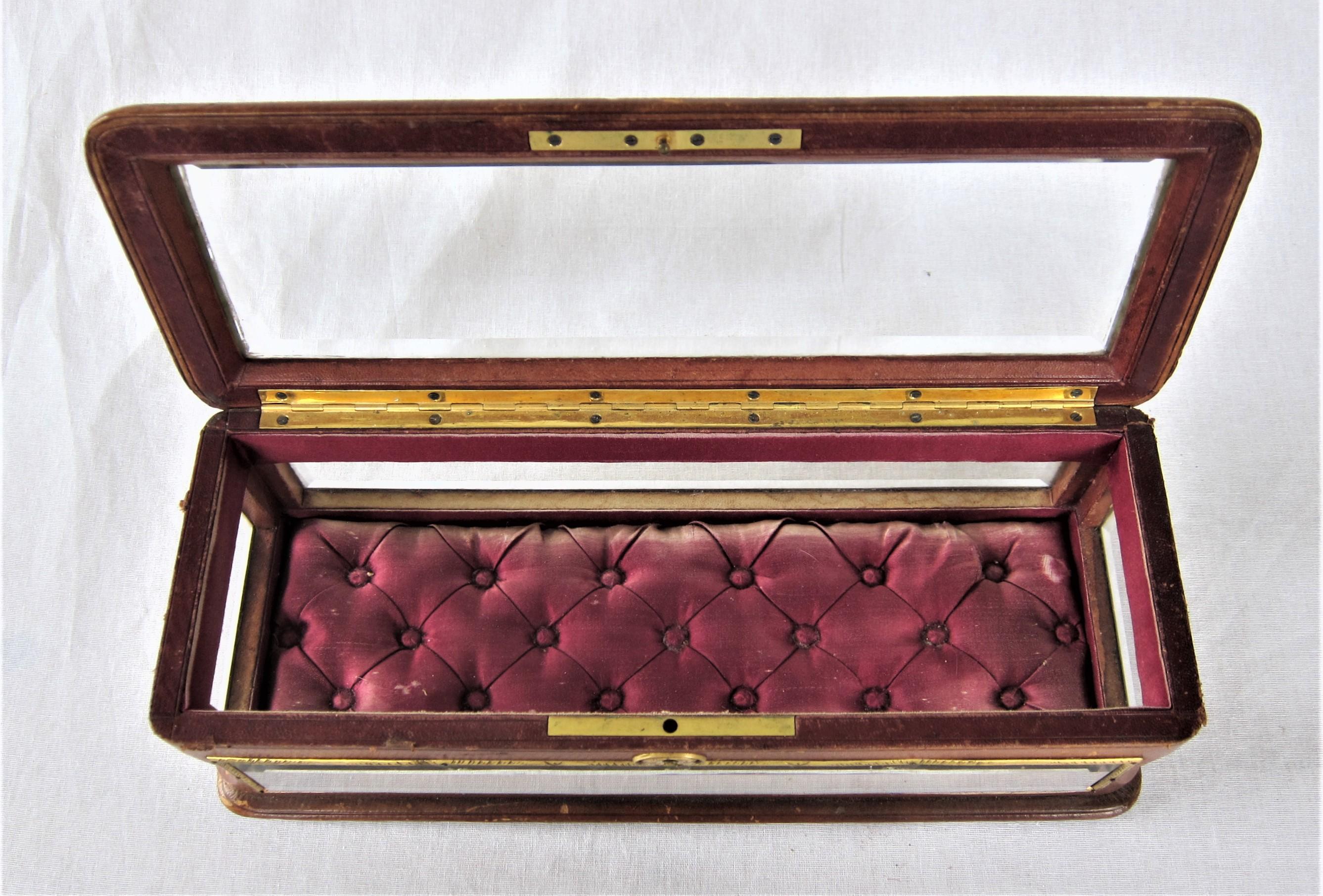 19th century French beveled glass and leather jewelry box, mounted with brass ornaments and keyhole. Upholstered with red silk inside.
Mark on the bottom: Horlogerie et Bijouterie, Eugene Allegre, Rue de Alger, Toulon.
 
