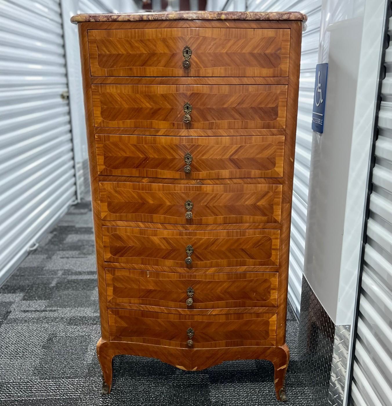 Un superbe semainier ancien de style Louis XV, fabriqué à la fin du 19e siècle ou au début du 20e siècle. Cette élégante commode à sept tiroirs est conçue pour un rangement d'une semaine, chaque tiroir étant destiné à un jour différent de la