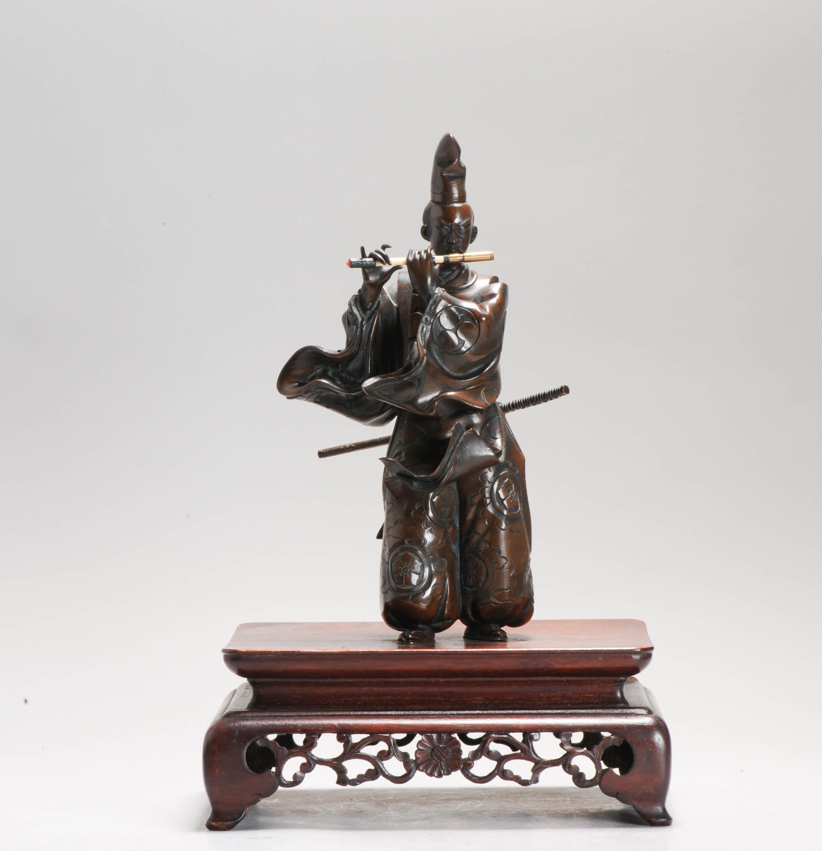 JAPAN - MEIJI period (1868 - 1912) Pair of bronze candlesticks with brown patina with copper and gilded bronze inlays depicting two standing women carrying lotus branches forming a candlestick, posing on quadripod bases decorated with lotus scrolls.