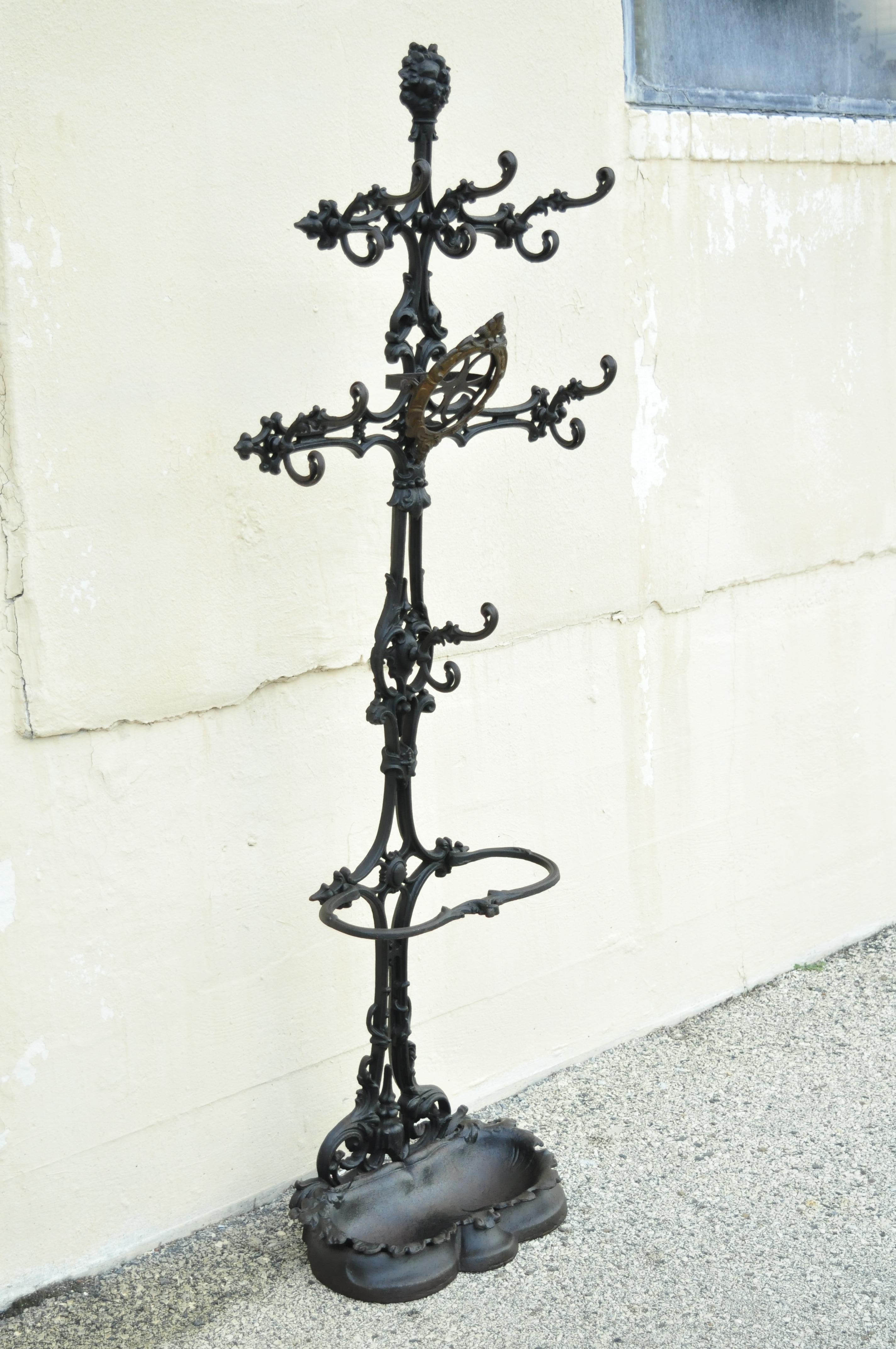 19th Century Antique Victorian cast iron rococo hall tree coat hook umbrella stand. Item features multiple ornate hooks, removable cast iron drip pan, frame for central mirror (glass missing, cast iron construction, very nice antique item, quality