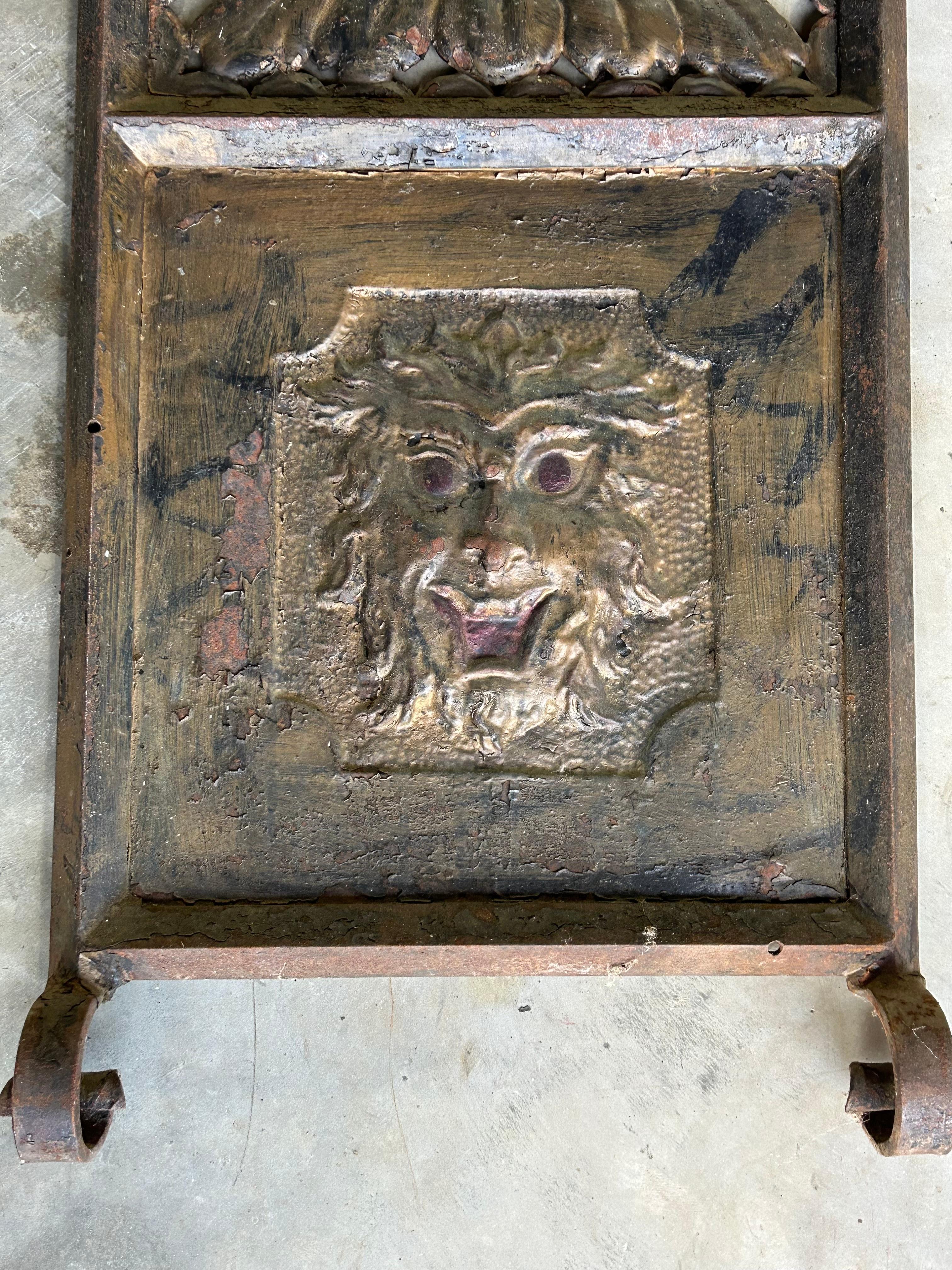 Rare 19th century hand wrought iron and tin entryway surround. Originally a coat rack, but also great for a garden entrance. Original bronze painted surface. Top central crest with medallion and mystical bird creatures. Legs with gargoyle faces, urn