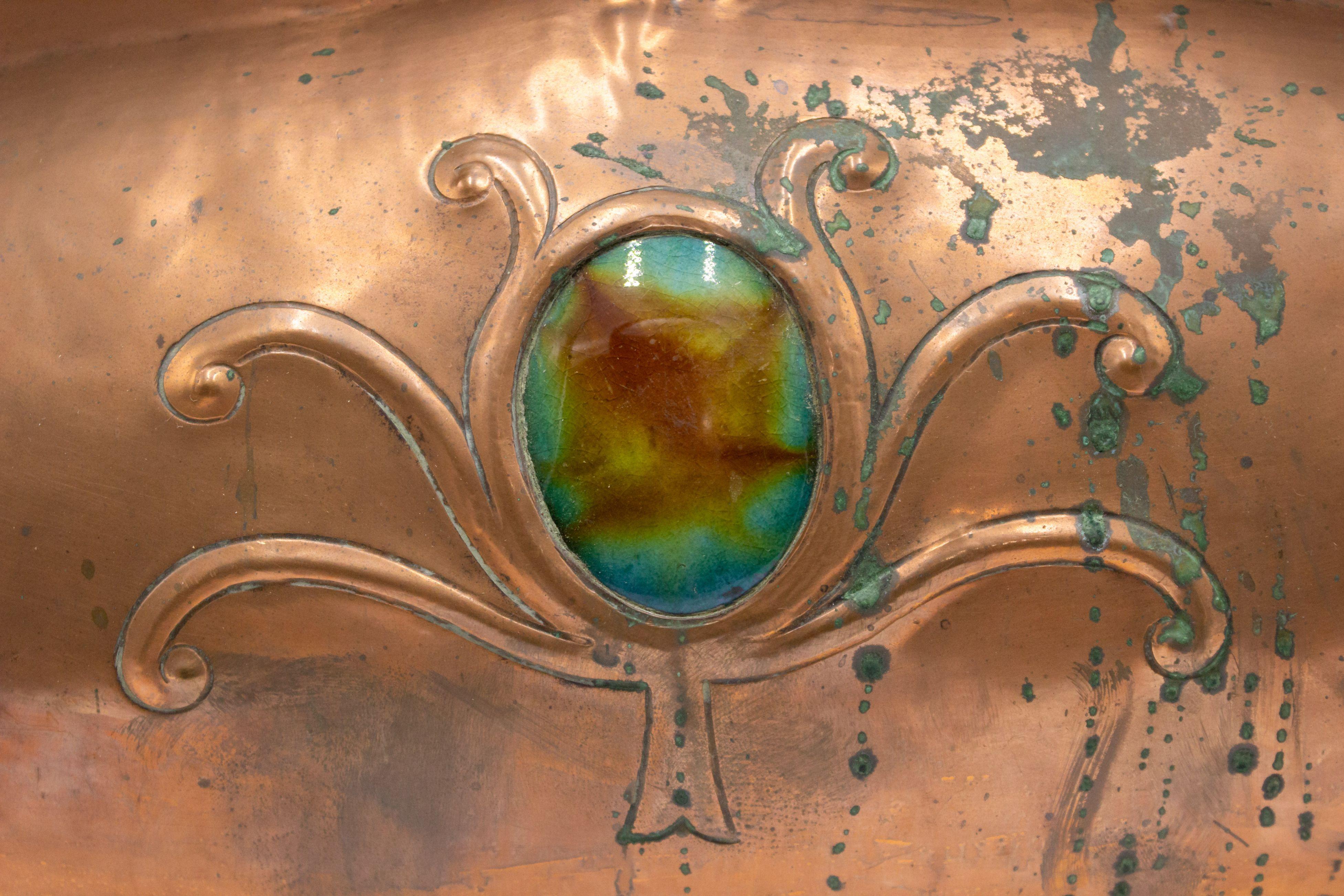 Grand coffre de table ou boîte en cuivre du mouvement Arts & Crafts anglais qui présente des saillies curvilignes de chaque côté, ainsi qu'un médaillon décoratif en émail vert sur le couvercle et la façade.