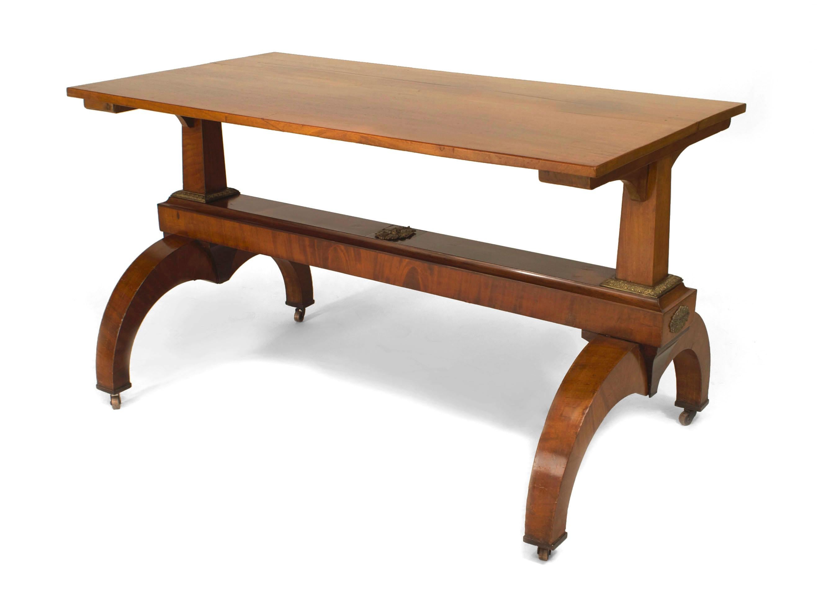 Mesa Biedermeier austriaca (s. XIX) de nogal con adornos de bronce en los lados de la base del pedestal unidos con una camilla.
