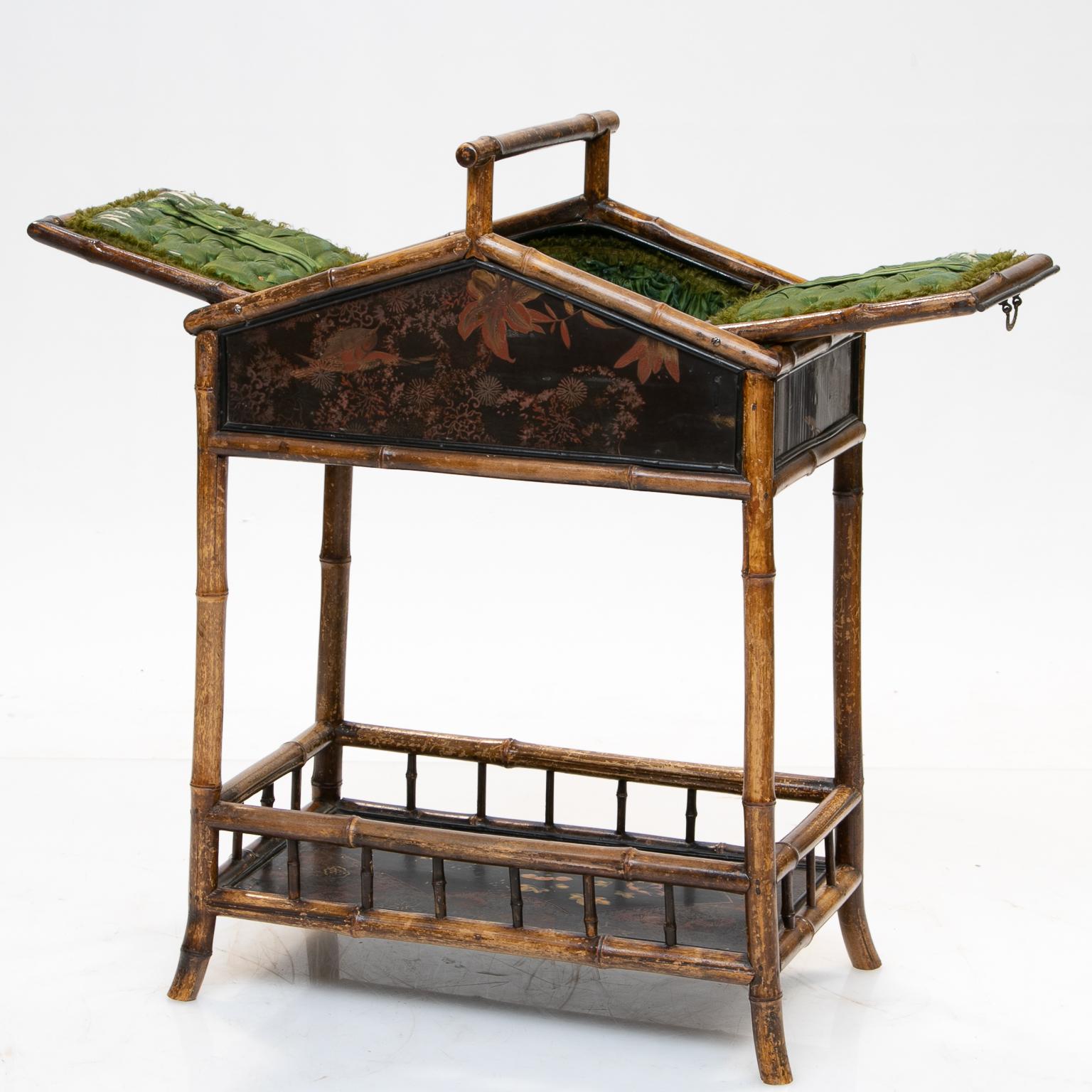 19th century bamboo and chinoiserie sewing stand
A unique double lift top sewing stand with chinoiserie panels and bamboo construction. The top is designed with two lifting doors with hardware revealing a tufted lined interior. Nice top handle.