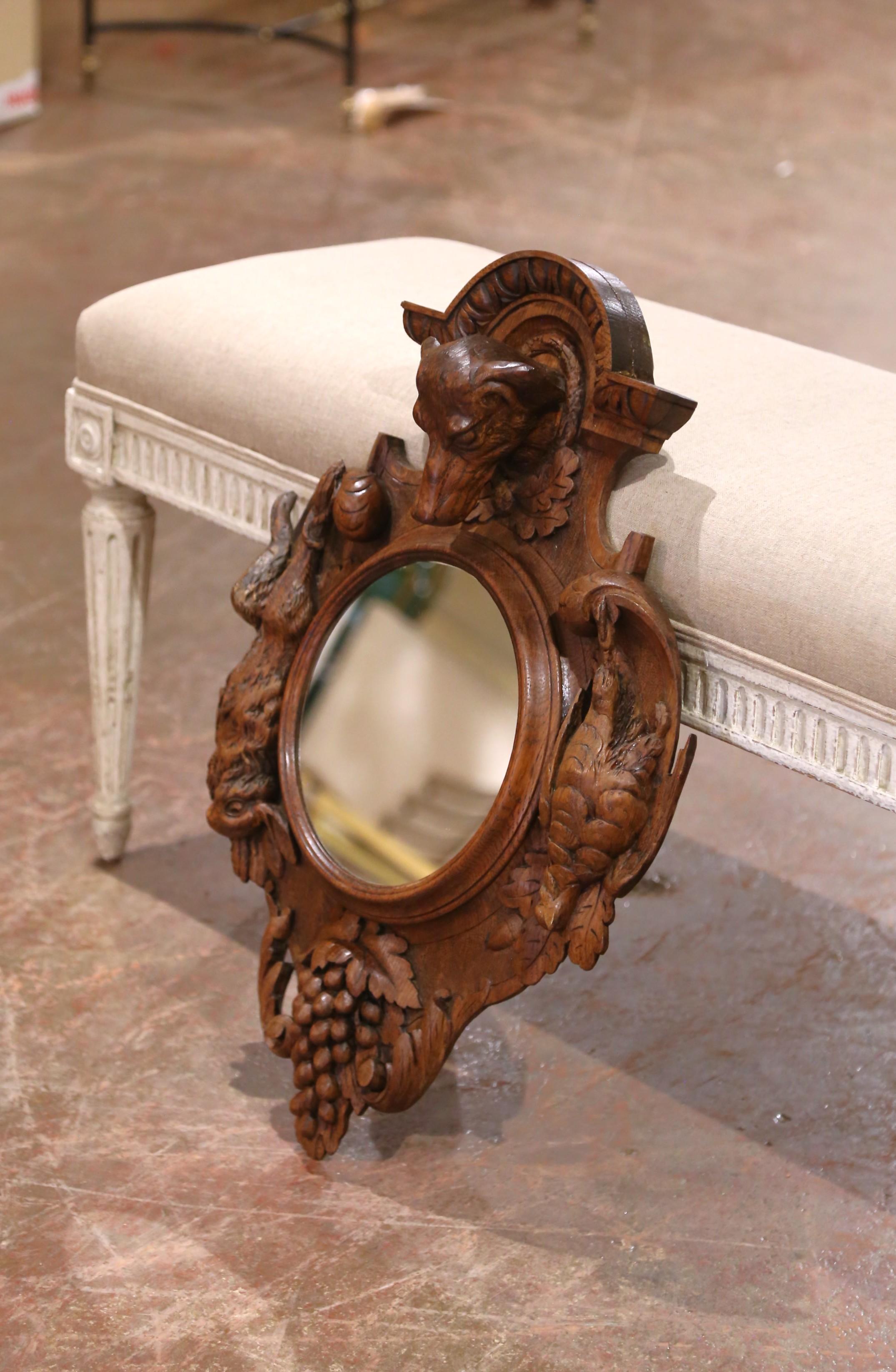 Decorate a study or hallway with this heavily carved antique mirror. Created in France circa 1880 and measuring just over two feet tall, the Black Forest frame features a boldly sculpted dog’s head at the crest, flanked by intricately rendered oak