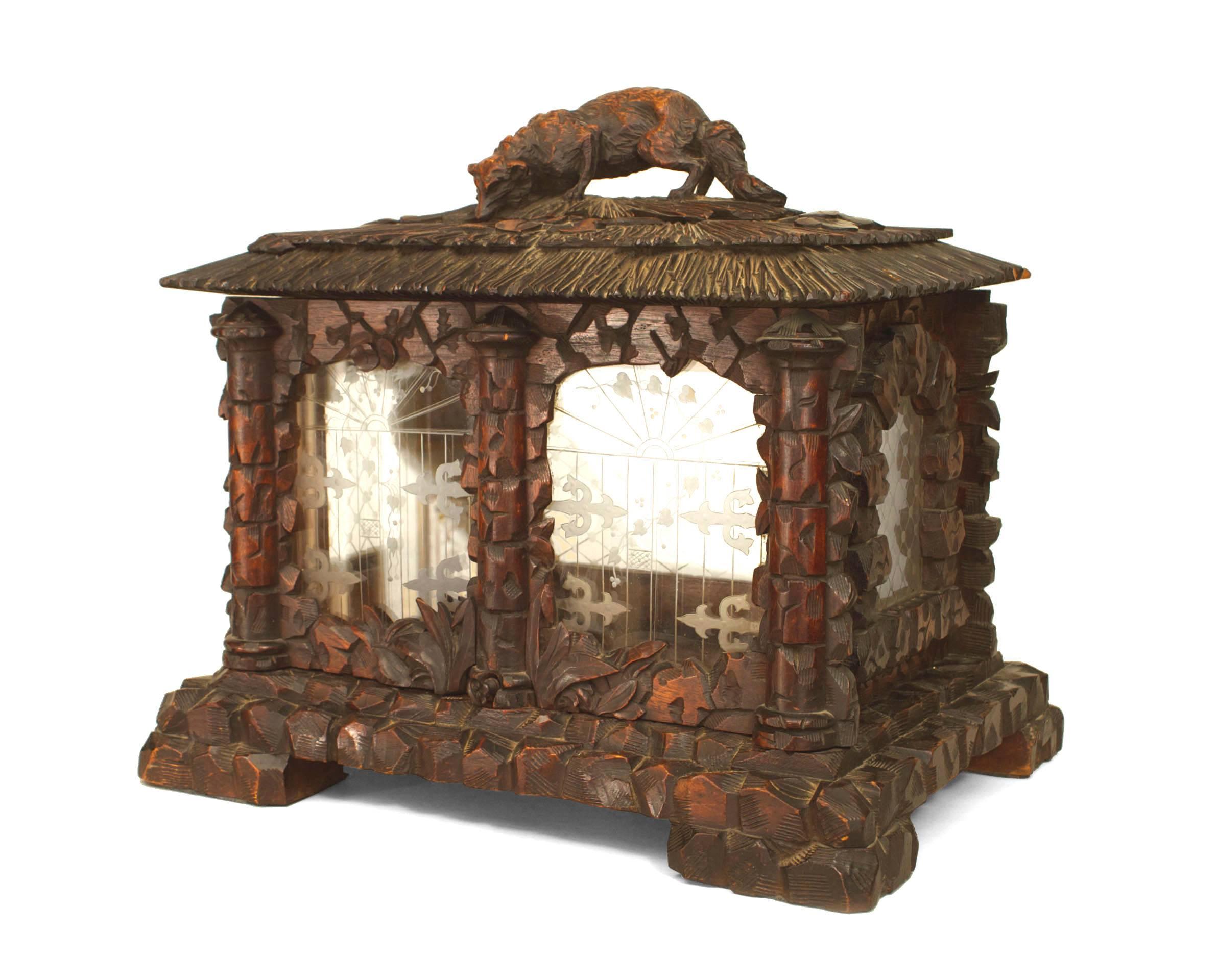 Rustic Black Forest (4th Quarter 19th Century) walnut carved table top display cabinet box with etched glass inset panels and floral carving with a top having a carved figure of a fox.
