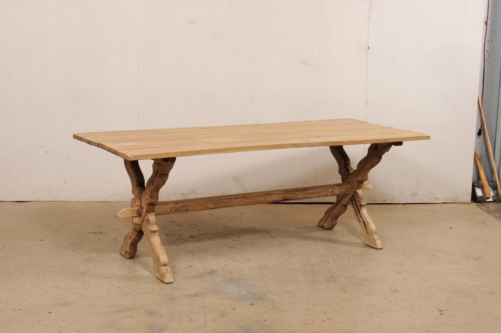 Ein französischer Tisch aus gebleichter Eiche mit großen Beinen aus dem 19. Jahrhundert. Dieser antike Tisch aus Frankreich hat eine rechteckige Platte aus vier Brettern, die auf einem Paar x-förmiger Bockbeine steht, die in einem märchenhaften,
