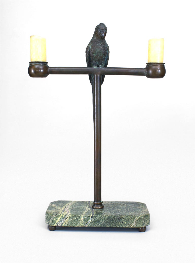 American Victorian (Late 19th Century) bronze life size parrot perched on a stand centering 2 candle holders and mounted on a rectangular green marble base.
  