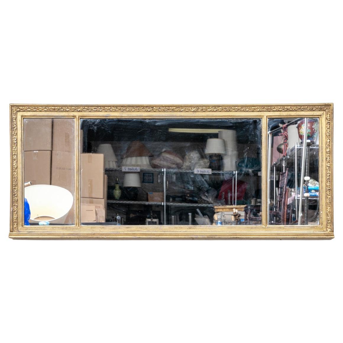 A fine Antique Gilt and Carved Mirror in the Federal style. The tripartite mirror with carved cornice over a fine thin leafy surround band on the sides and bottom. The wire on verso for hanging shows the top cornice at the bottom as reflected in the
