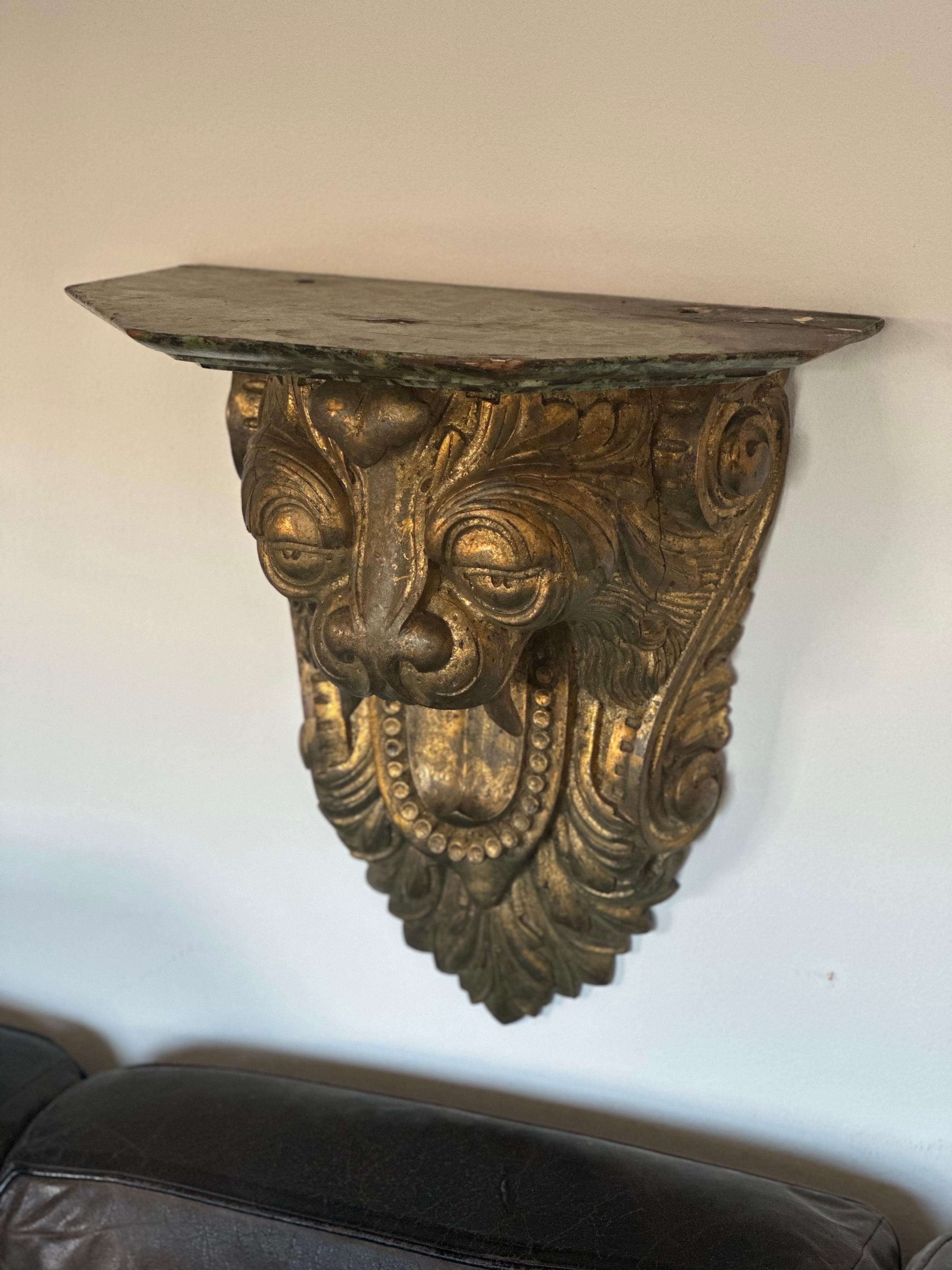 19th C carved and gilt lion wall shelf. 
Amazing stylization. Whimsical. Faux marble painted top. 
Carved in oak. 