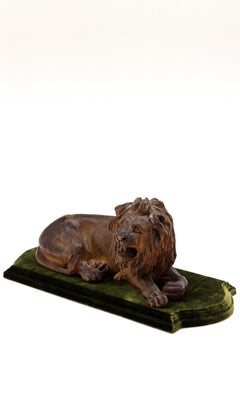 19th Century Carved Wooden Reclining Lion on a Green Velvet Base
