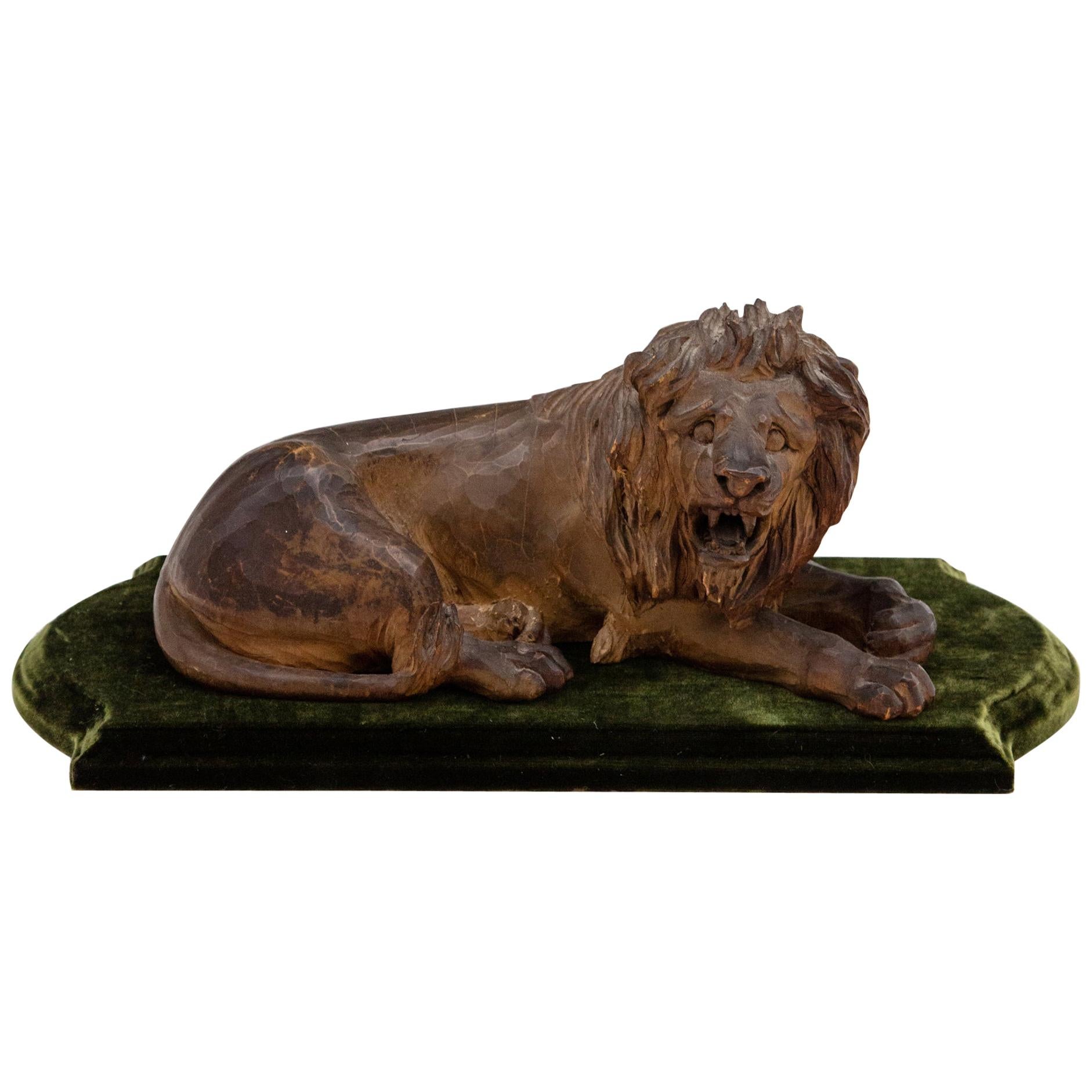19th Century Carved Wooden Reclining Lion on a Green Velvet Base