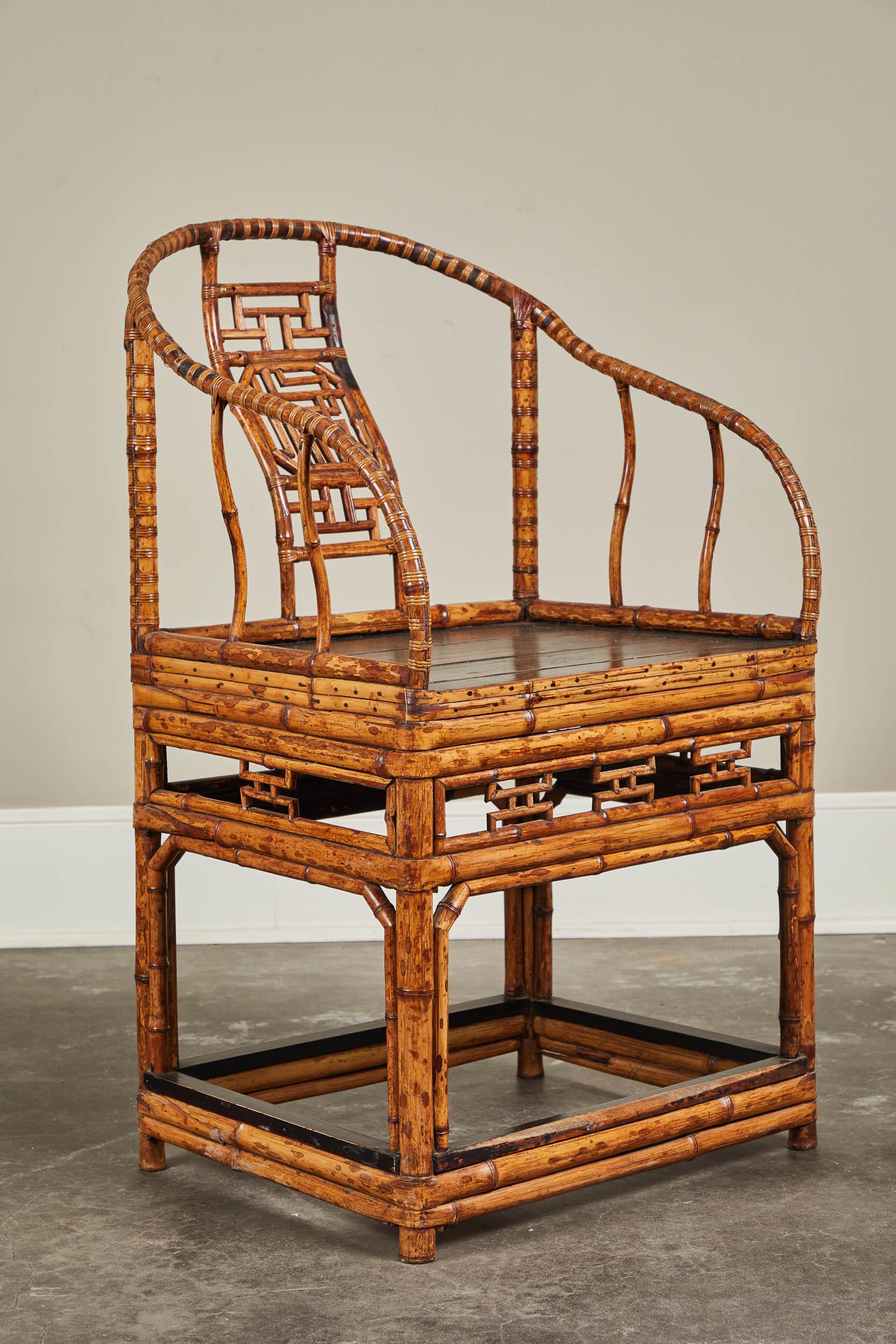 A 19th century Chinese horseshoe back armchair. Made from sturdy bamboo with a black lacquered seat and back splat details.
