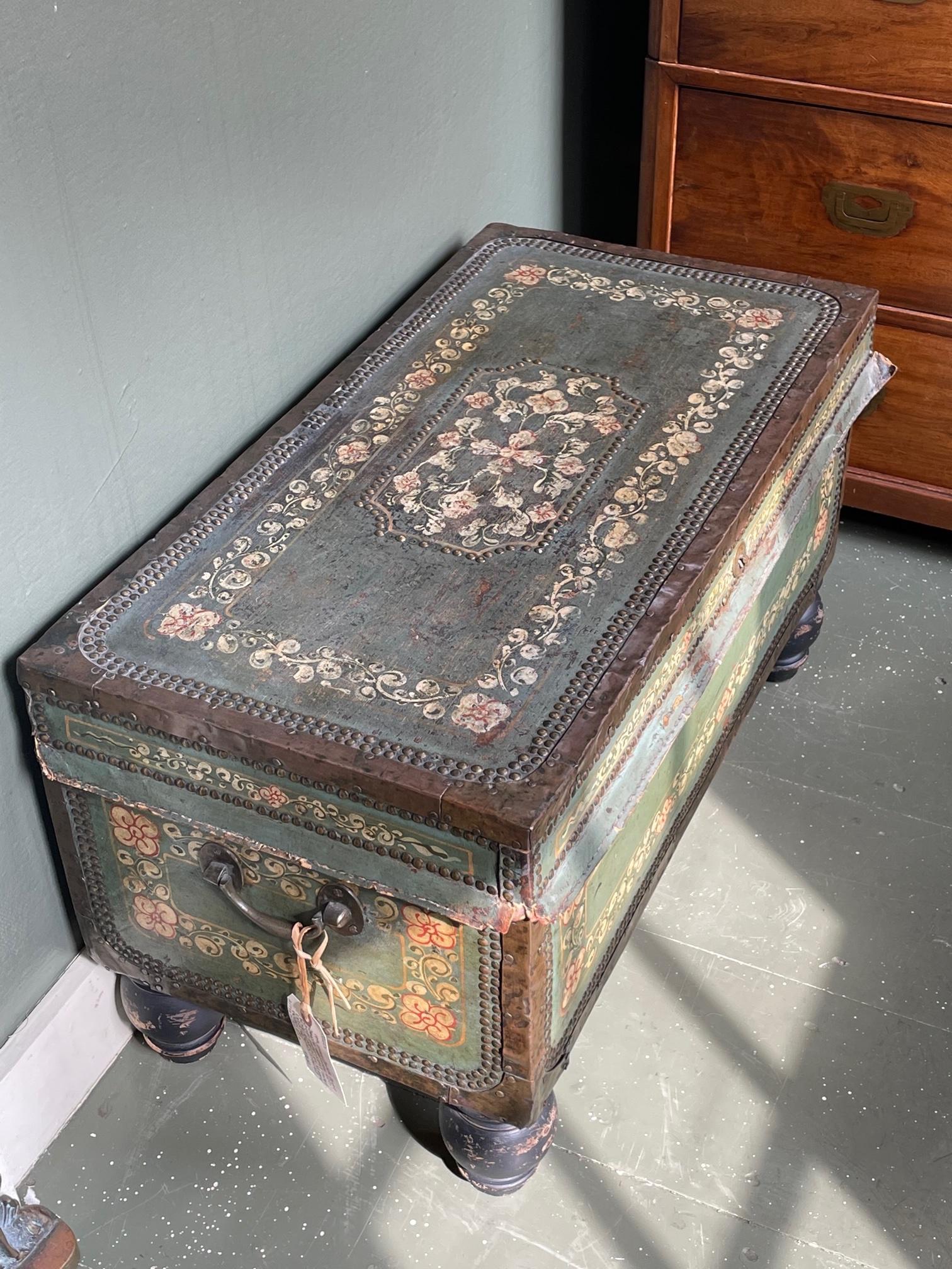Early 19th century Chinese Camphor wood trunk, made for export. With applied leather exterior handpainted with various flowers and decorated with brass nailhead trim. On turned feet.