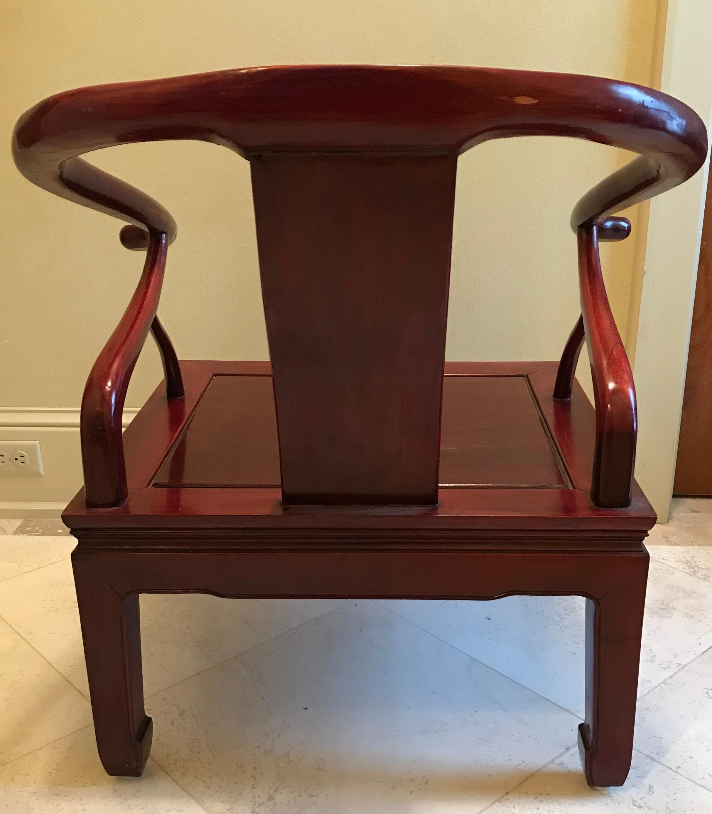 These Classic red lacquer bent elm Chinese chairs are simple yet powerful. With curved arms and detailed square legs, they epitomize the most refined of this genre. The back has a simple Shou longevity symbol carved in the center and a circle within