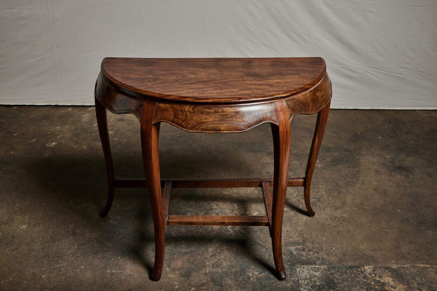 A beautiful Chinese rosewood demilune table, circa the 1880s. The apron on this Chinese demilune table has a gently scalloped shape. It also has elegantly curved legs and a lovely deep finish.