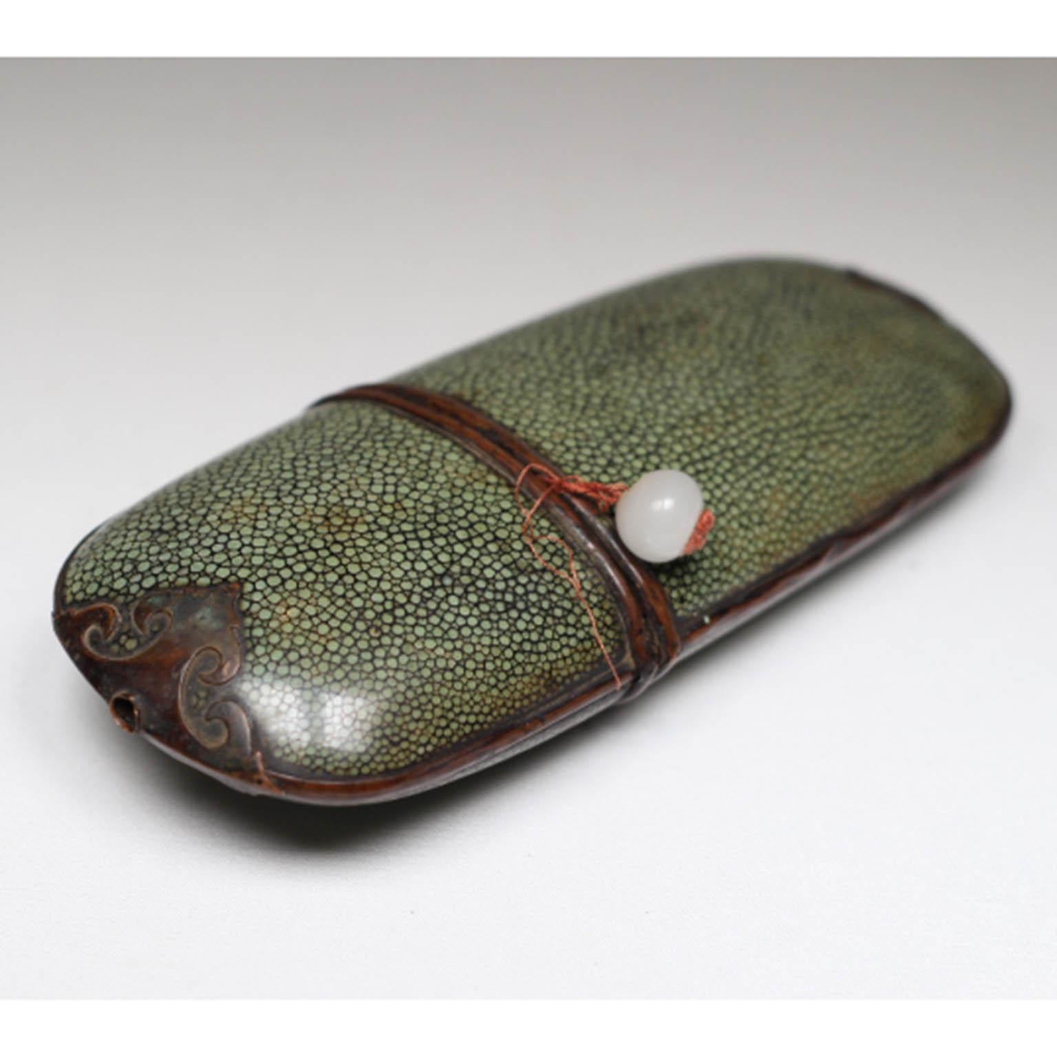 Antique Chinese Shagreen covered eyeglasses case with onyx. The case is fashioned from two pieces of wood which are covered in beautifully patterned shagreen (sharkskin) and copper accents.
The string has been broken and retied together.
