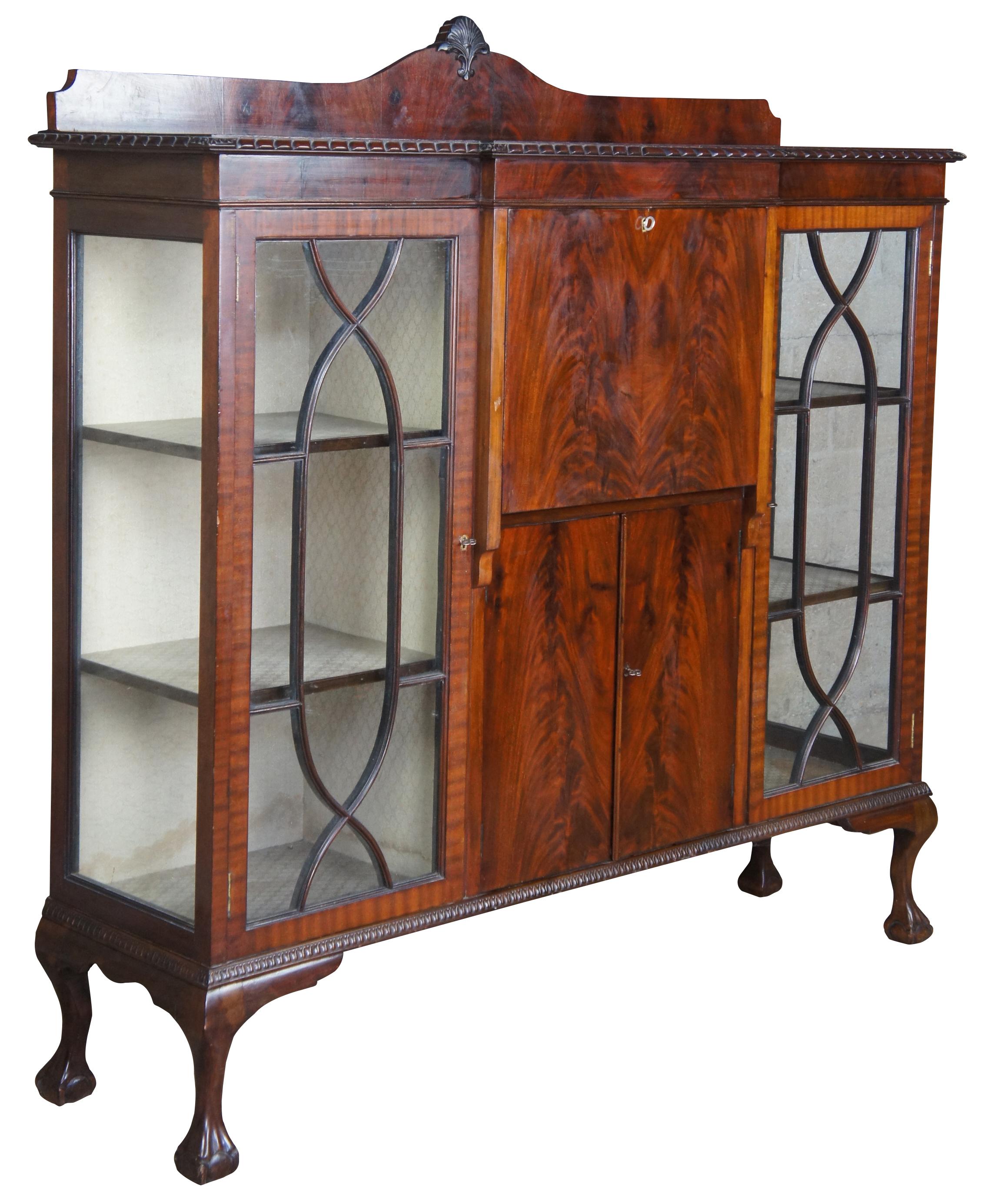 Exquisite 19th century Chippendale style side by side secretary. A rectangular case with breakfront design made from crotch mahogany with carved backsplash. Features a drop front writing desk flanked by bookcases. The petite secretary opens to a