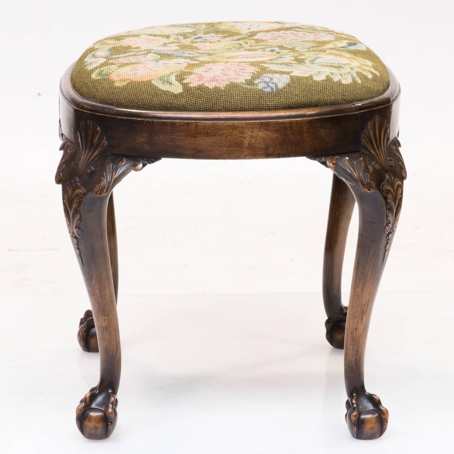 A 19th century Chippendale walnut oval stool with tapestry seat and resting on a claw and ball foot. Well-proportioned cabriole legs with detailed carved knee's. This bench has a shaped apron with shell carvings. One way to tell the quality is to