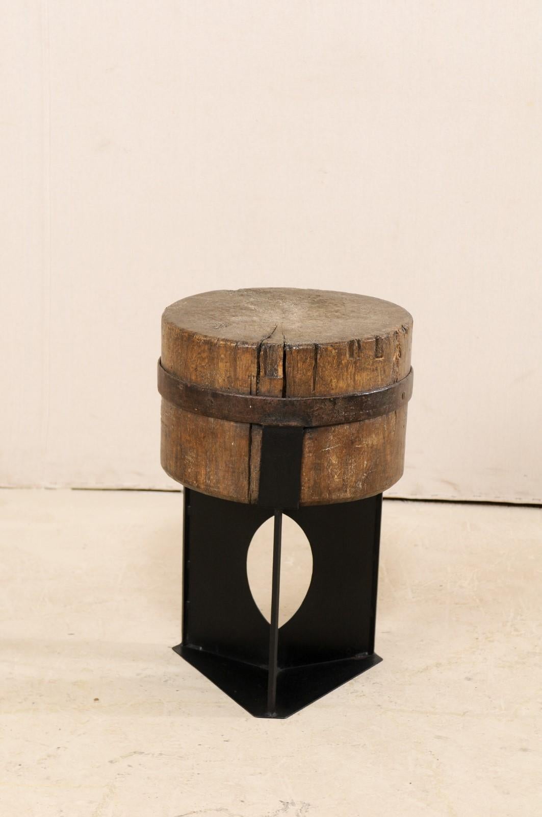 This modern-designed side table has been custom fashioned with a European 19th century chopping block top mounted onto a contemporary black iron base. This unique and one-of-a-kind piece has been created with an intriguing mix of rustic and modern